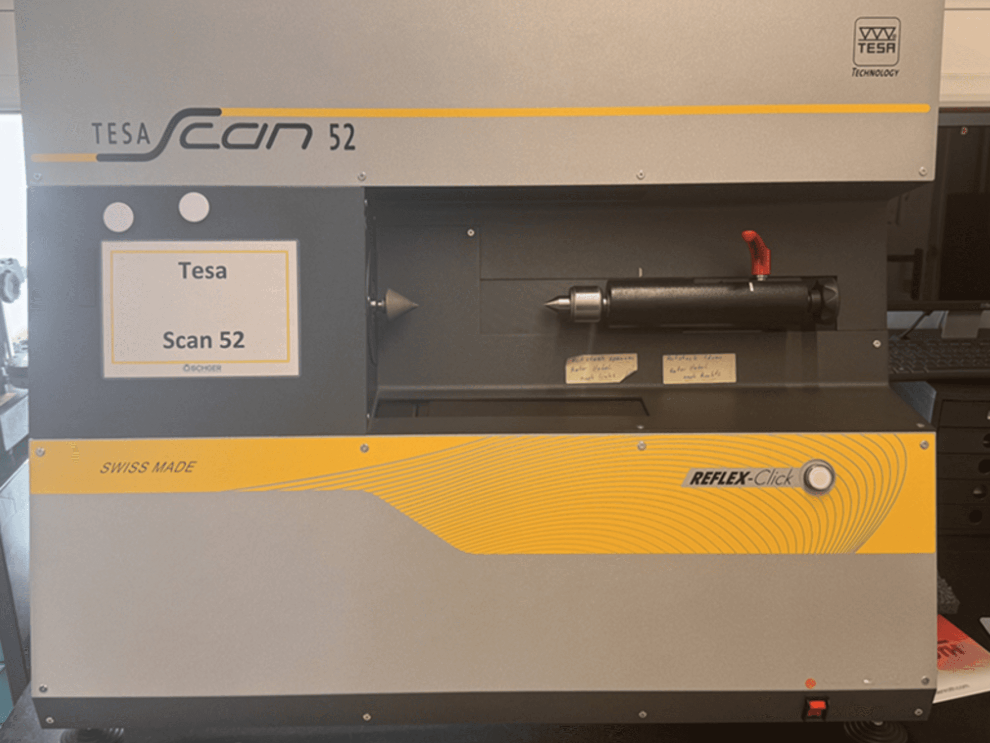 Vista frontal de la máquina de medición óptica TESA Scan 52, en la que se aprecian los botones de control y la etiqueta «SWISS MADE».