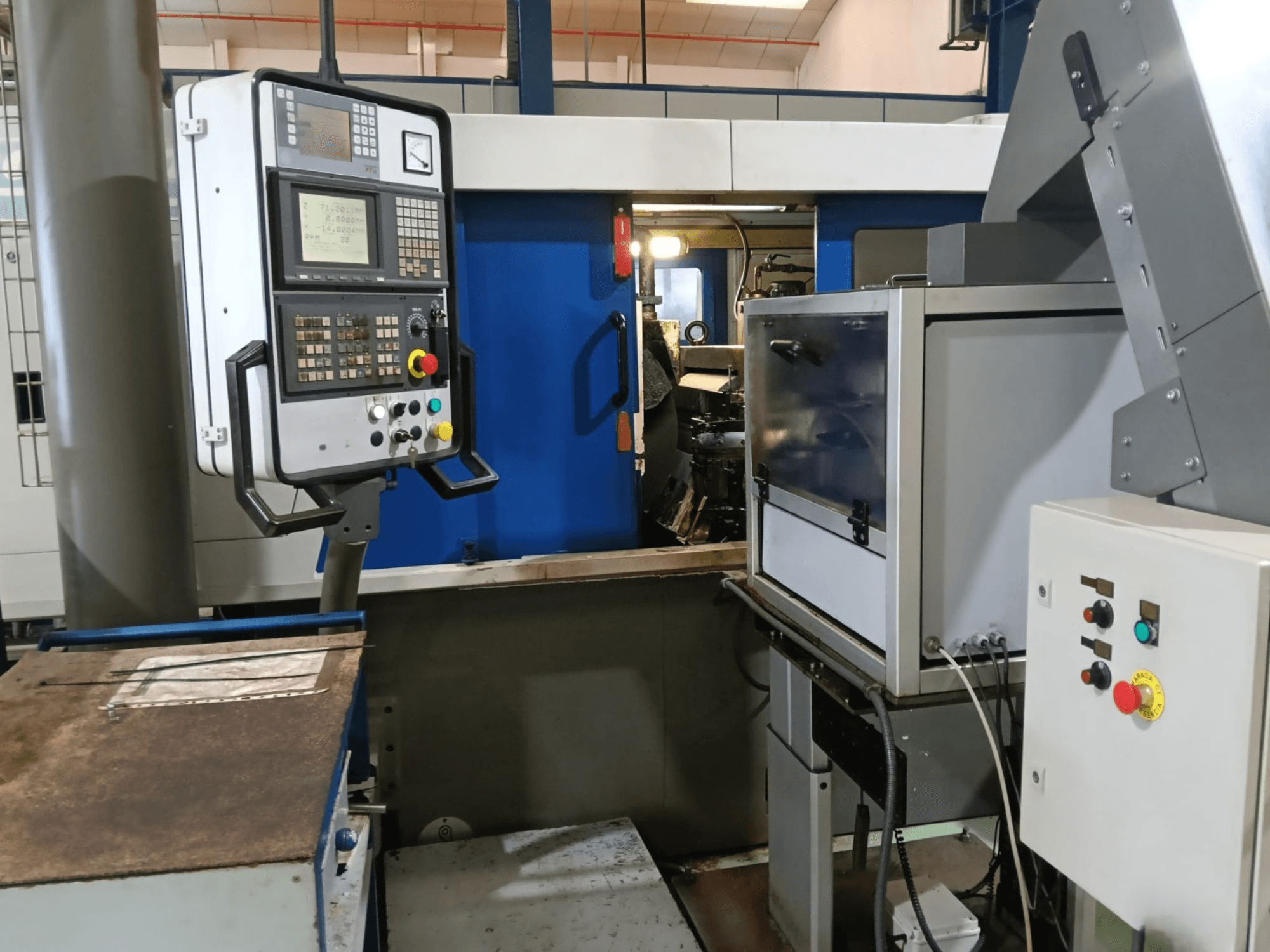 Panel de control y maquinaria de la rectificadora sin centros DANOBAT 327 MDA, vista desde el lateral, mostrando los botones y la pantalla.