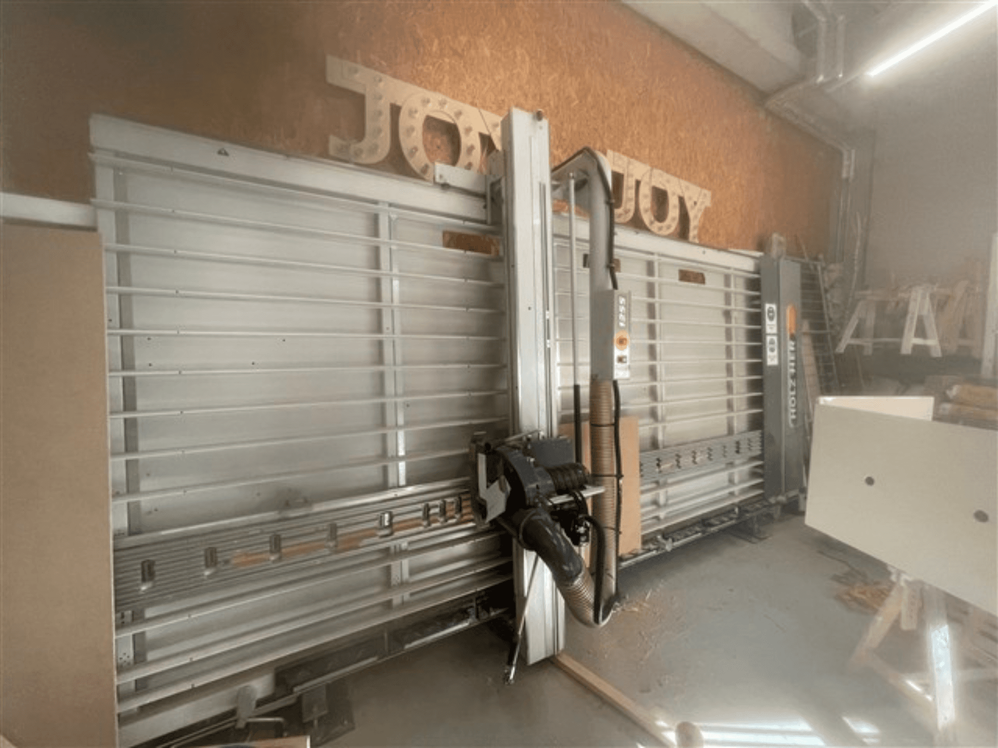 Sierra horizontal para tableros, marca Holz-Her, vista lateral, muestra la hoja de sierra, la extracción de polvo y el espacio de almacenamiento.