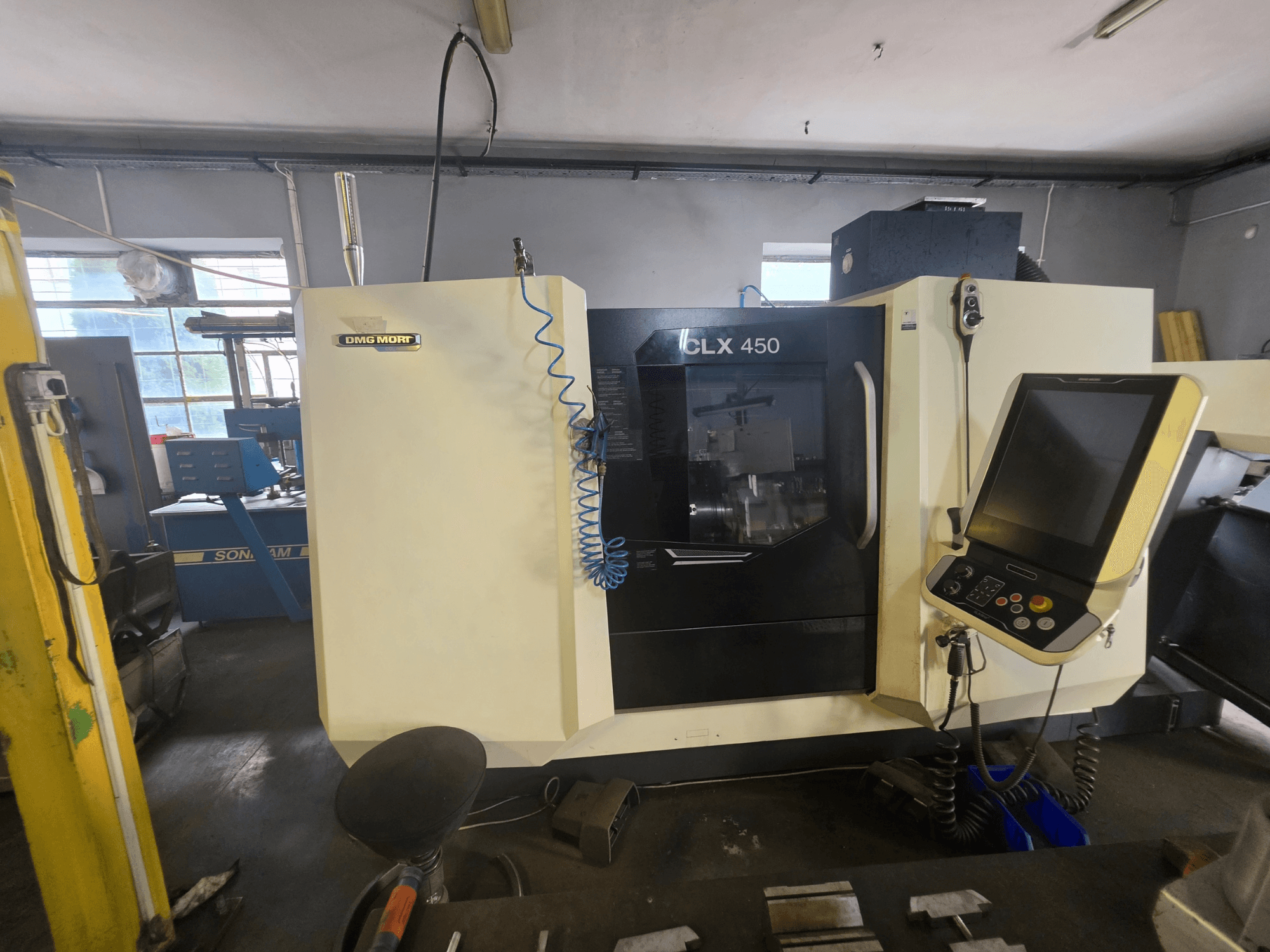 Torno horizontal DMG MORI CLX 450 V6 visto de frente, con el panel de control y el logotipo de la marca a la vista.