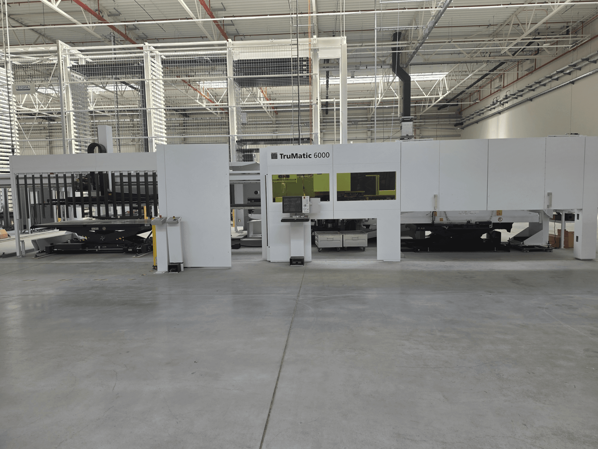 Sistema automatizado de producción de chapa TRUMPF TruMatic 6000, vista frontal, en la que se aprecian el panel de control y la zona de carga.