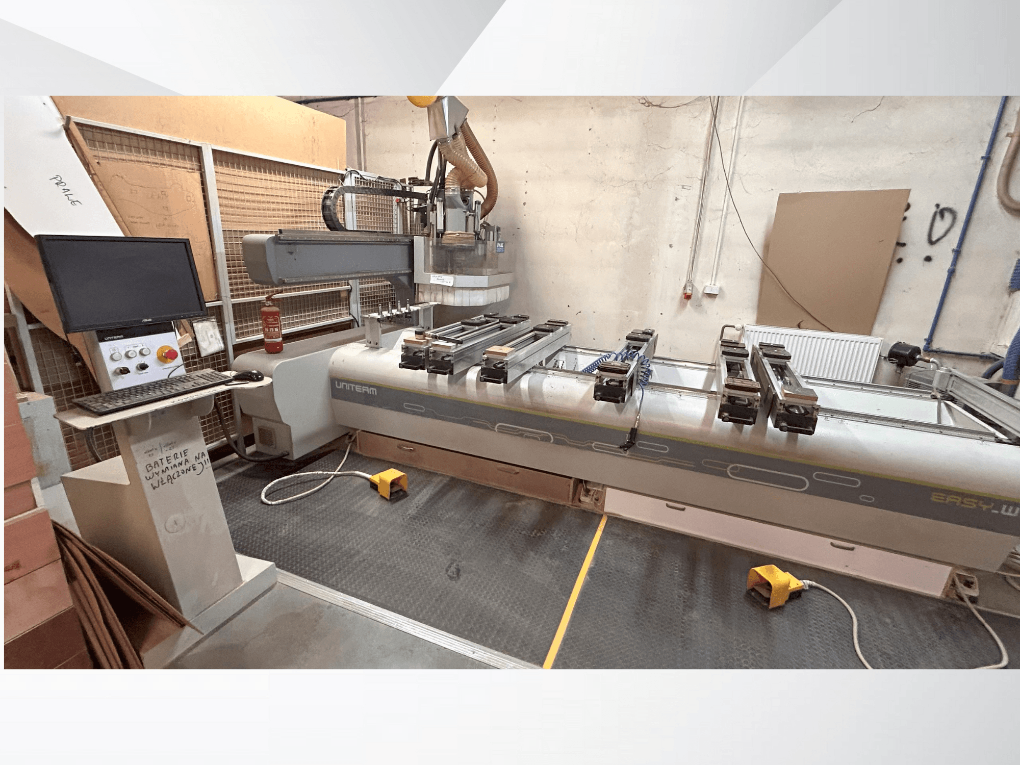 Vista frontal de una máquina CNC UNITEM EASY-W, con panel de control, monitor y piezas sujetas en la mesa de trabajo.