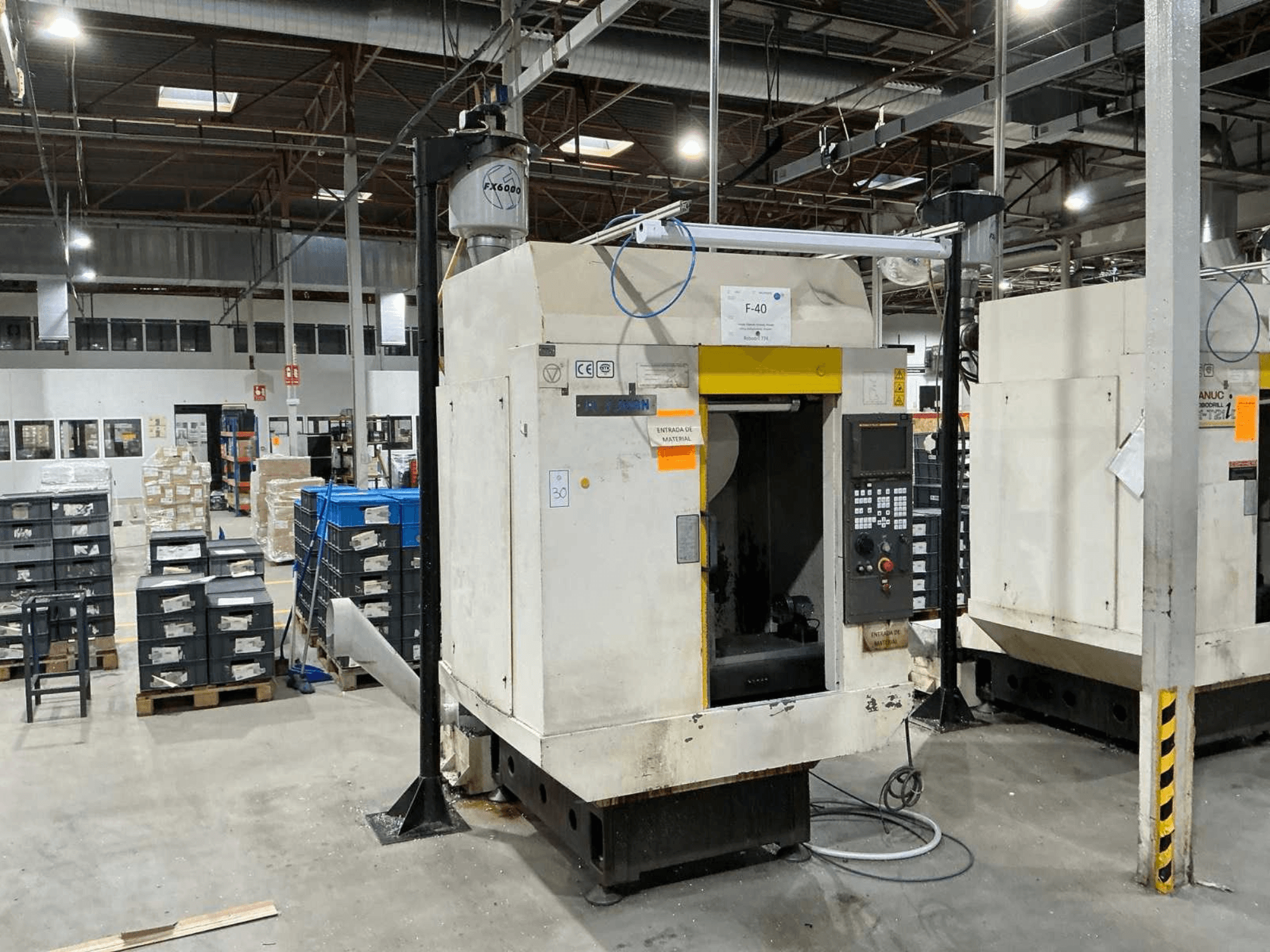 FANUC ROBODRILL α-T21iD, vista frontal del centro de mecanizado vertical en un entorno industrial, con los detalles del panel de control visibles.