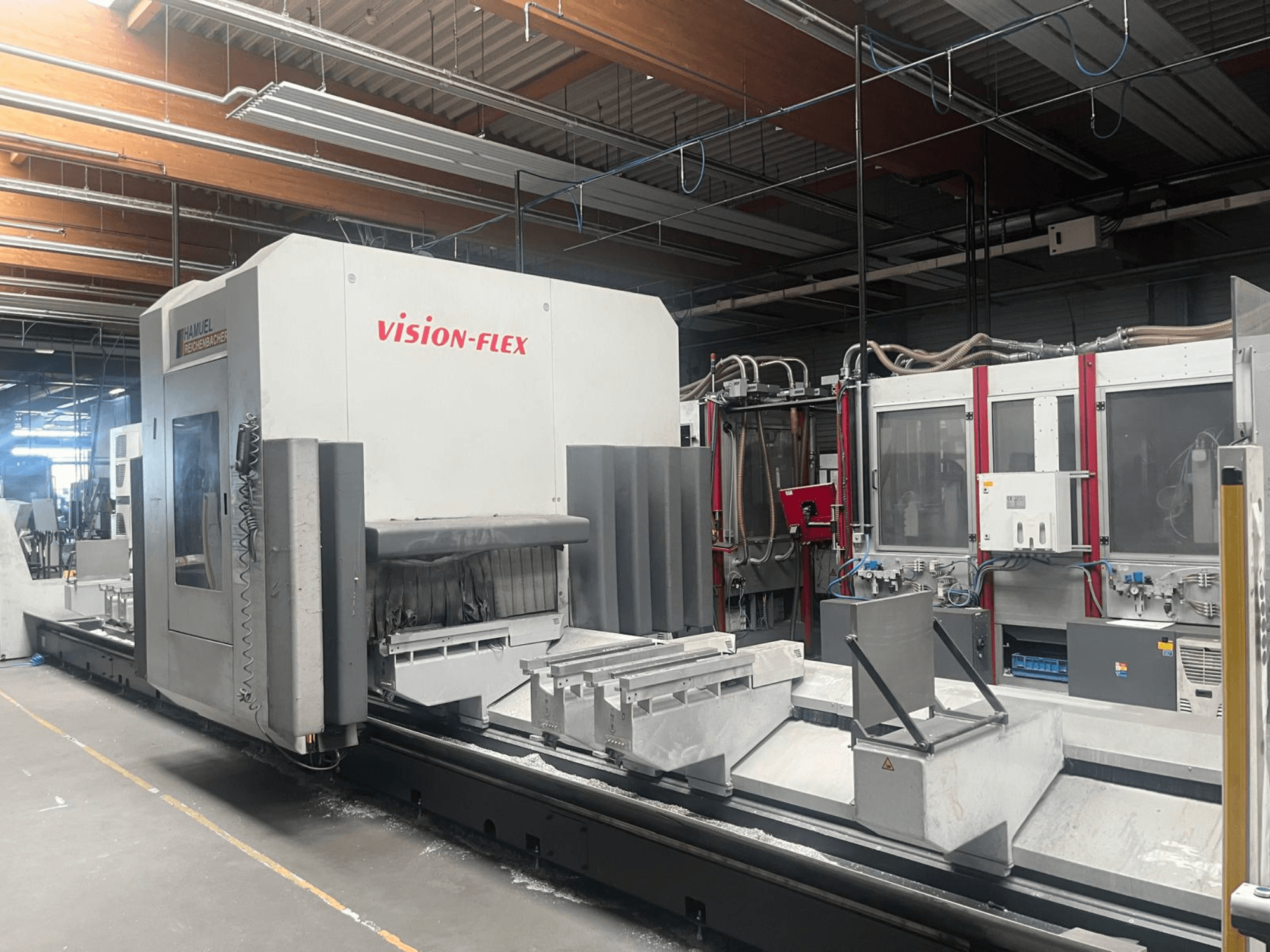 Centro de mecanizado vertical Hamuel Reichenbacher Vision Flex, vista lateral en la que se aprecian la zona de trabajo y los mandos en un entorno industrial.