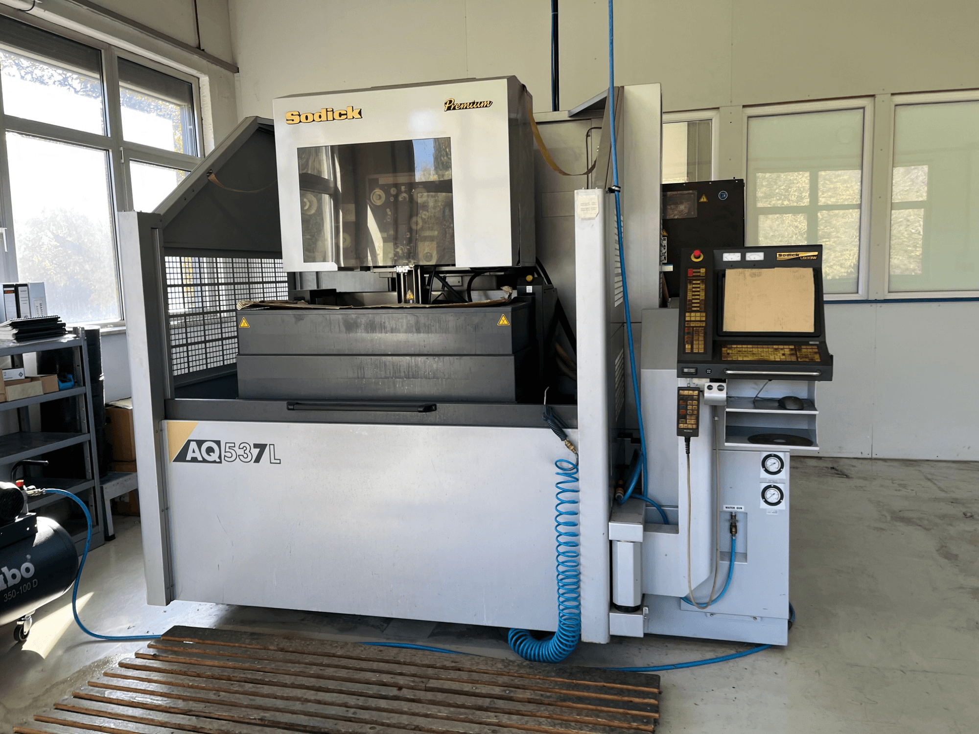 Máquina de electroerosión (EDM) Sodick AQ537L en vista frontal, con panel de control, conductos de refrigeración por agua y espacio de trabajo.