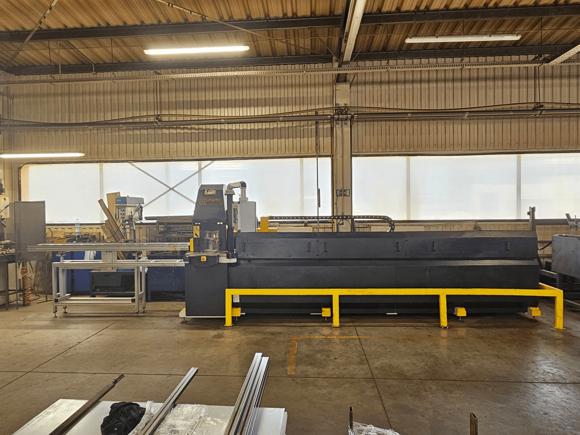 Máquina punzonadora CNC PARS HMP SIRIUS PLUS-3000/3-L1, vista frontal en un entorno industrial con superficies metálicas y herramientas.