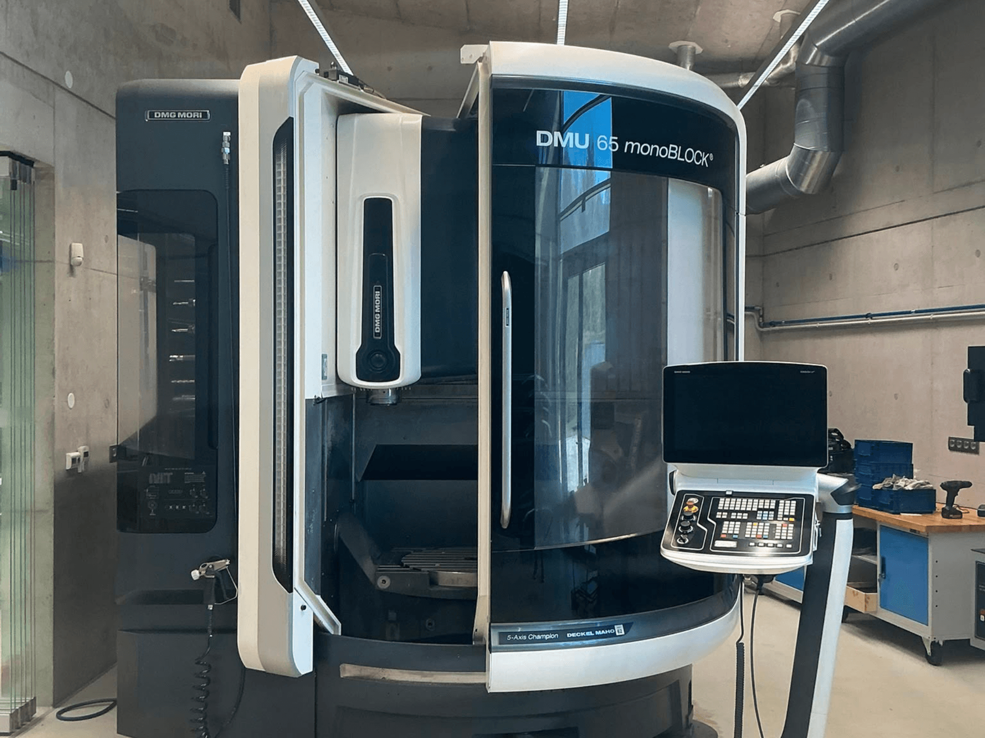 Centro de mecanizado vertical DMG MORI DMU 65 monoBLOCK, vista frontal, en la que se aprecian el panel de control y los detalles de la máquina en un entorno de taller.