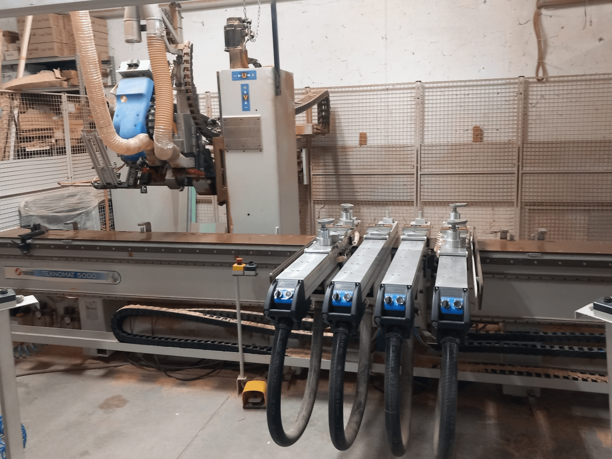 Centro de mecanizado de madera CNC MASTERWOOD TEKNOMAT 5000, vista frontal en la que se aprecian el cabezal de herramientas y las múltiples mangueras de aspiración.