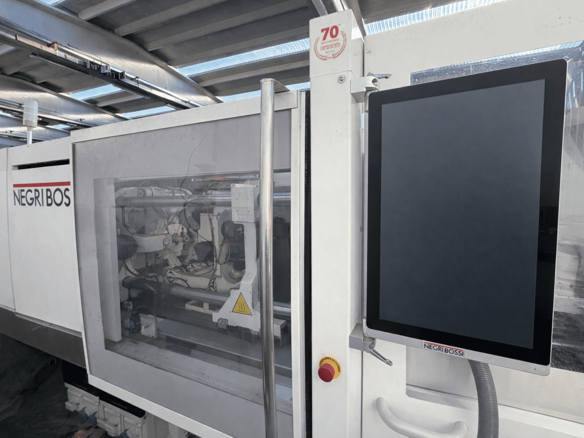 Inyectora eléctrica Negri Bossi ELE 80, vista frontal con pantalla de control y componentes internos visibles.