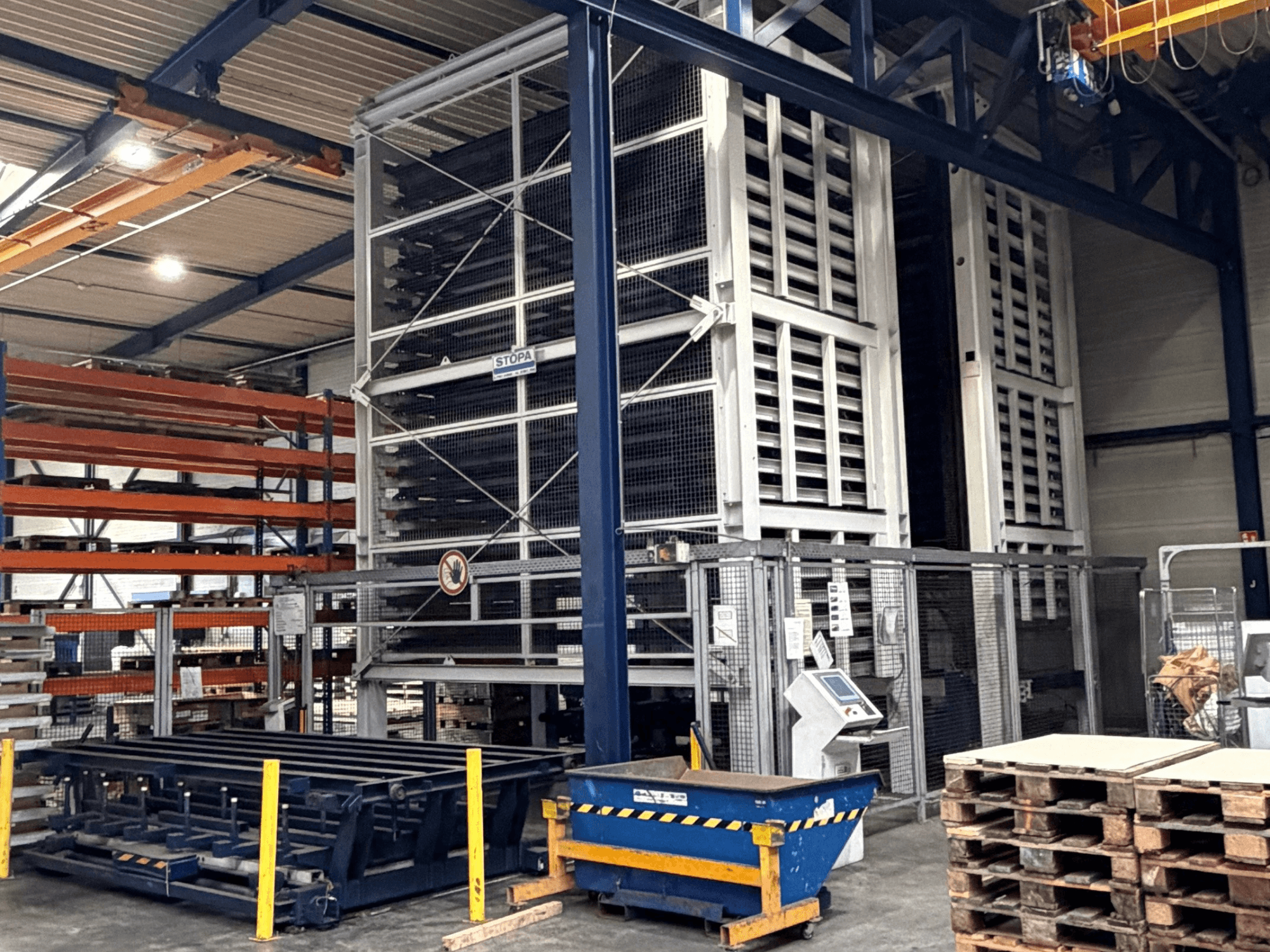 Sistema de automatización TRUMPF STOPA 4000x2000 en un almacén, vista lateral mostrando las estanterías y el panel de control dentro de la zona de almacenamiento.