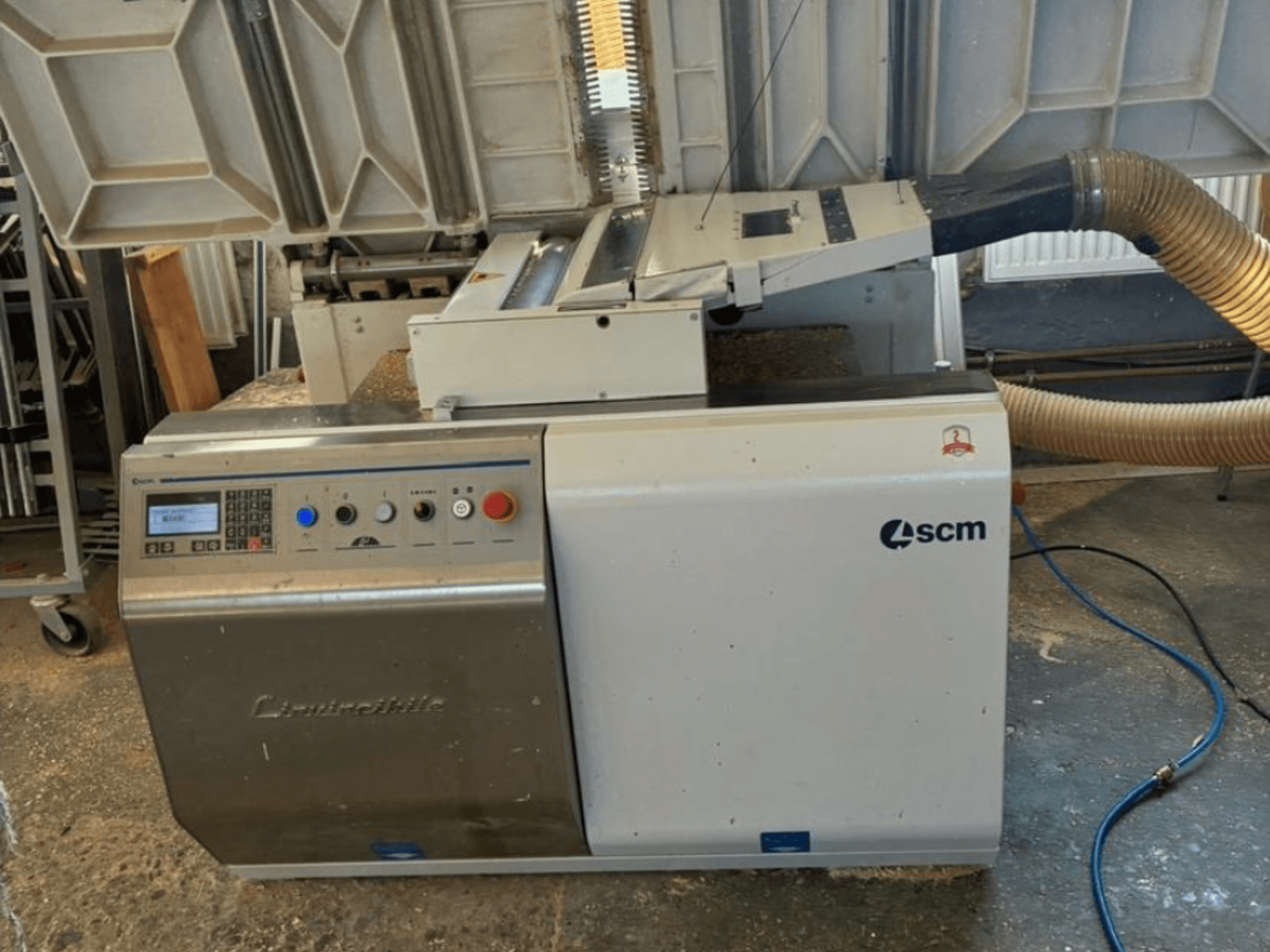 Encoladora de cantos SCM Centauro en vista frontal, mostrando el panel de control, la manguera de aspiración y el área de trabajo abierta para la aplicación de cantos.