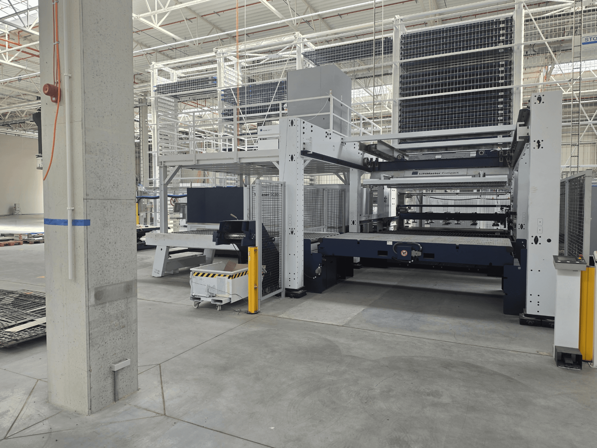 Vista frontal de la TRUMPF TruLaser 5030 fiber L76 FMC, en la que se muestra la máquina de corte por láser de fibra en un amplio entorno industrial.