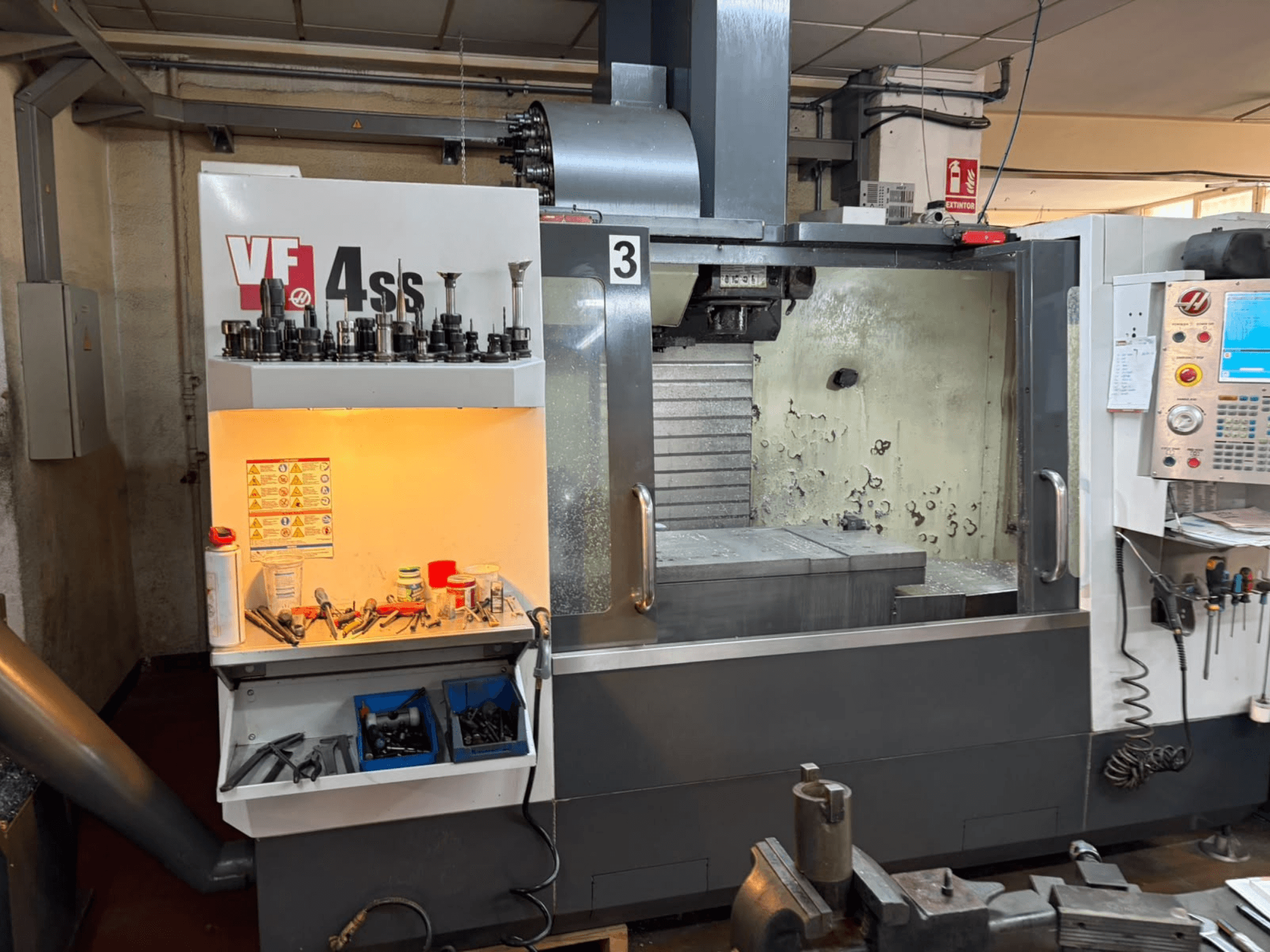Centro de mecanizado vertical HAAS VP 4SS, vista frontal, en la que se aprecian el almacén de herramientas, el panel de control y la zona de trabajo visible con detalles del mecanizado.