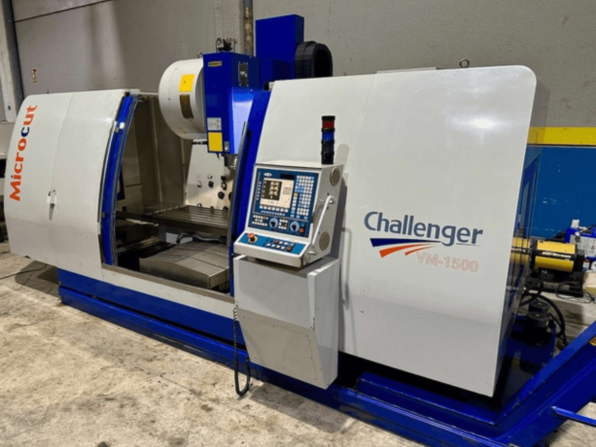 Máquina CNC Microcut Challenger VM-1500, vista frontal, cuenta con panel de control, espacio de trabajo y una base azul.
