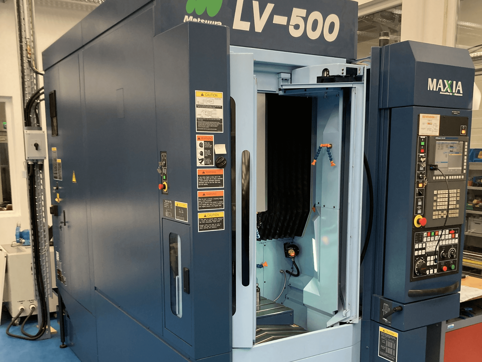 Centro de mecanizado vertical Matsuura LV-500 mostrado desde una vista frontal, con una puerta abierta y un panel de control con botones.