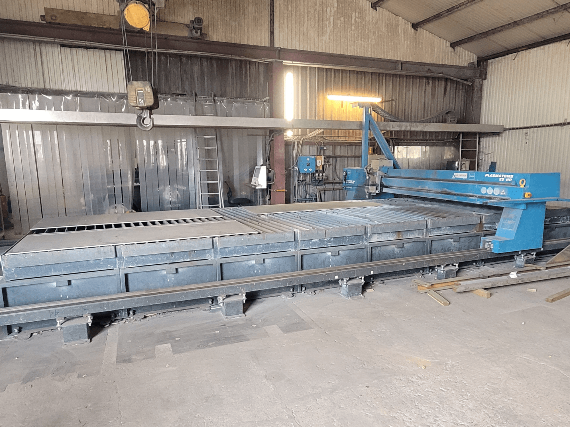 Máquina de corte por plasma SAF Plasmatone 25Hp, vista lateral, mostrando la bancada de corte y los componentes operativos en un entorno industrial.