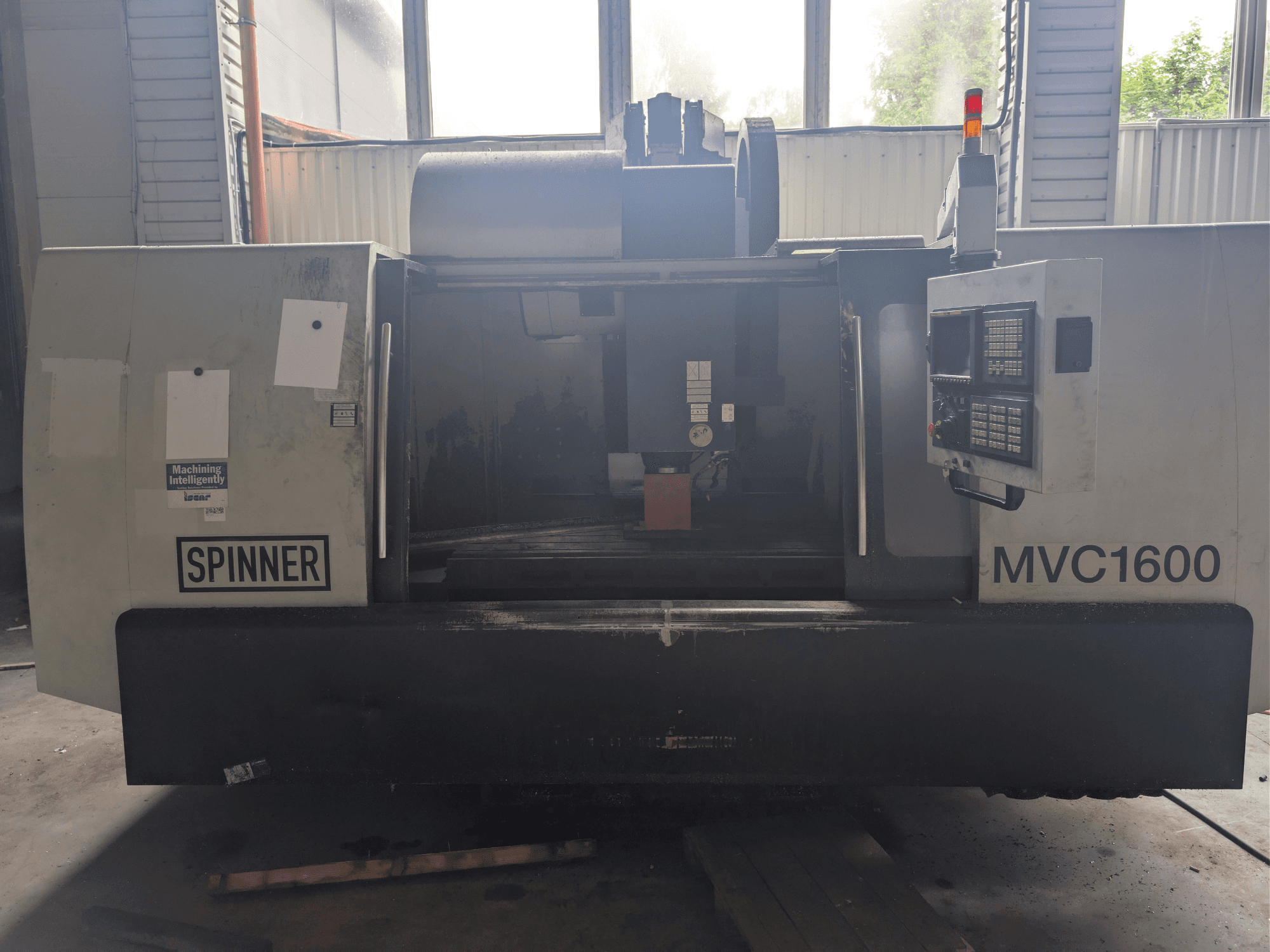 Centro de mecanizado vertical SPINNER MVC-1600, vista frontal, en la que se aprecian el panel de control y la zona de mecanizado. Adecuado para el mecanizado de precisión.