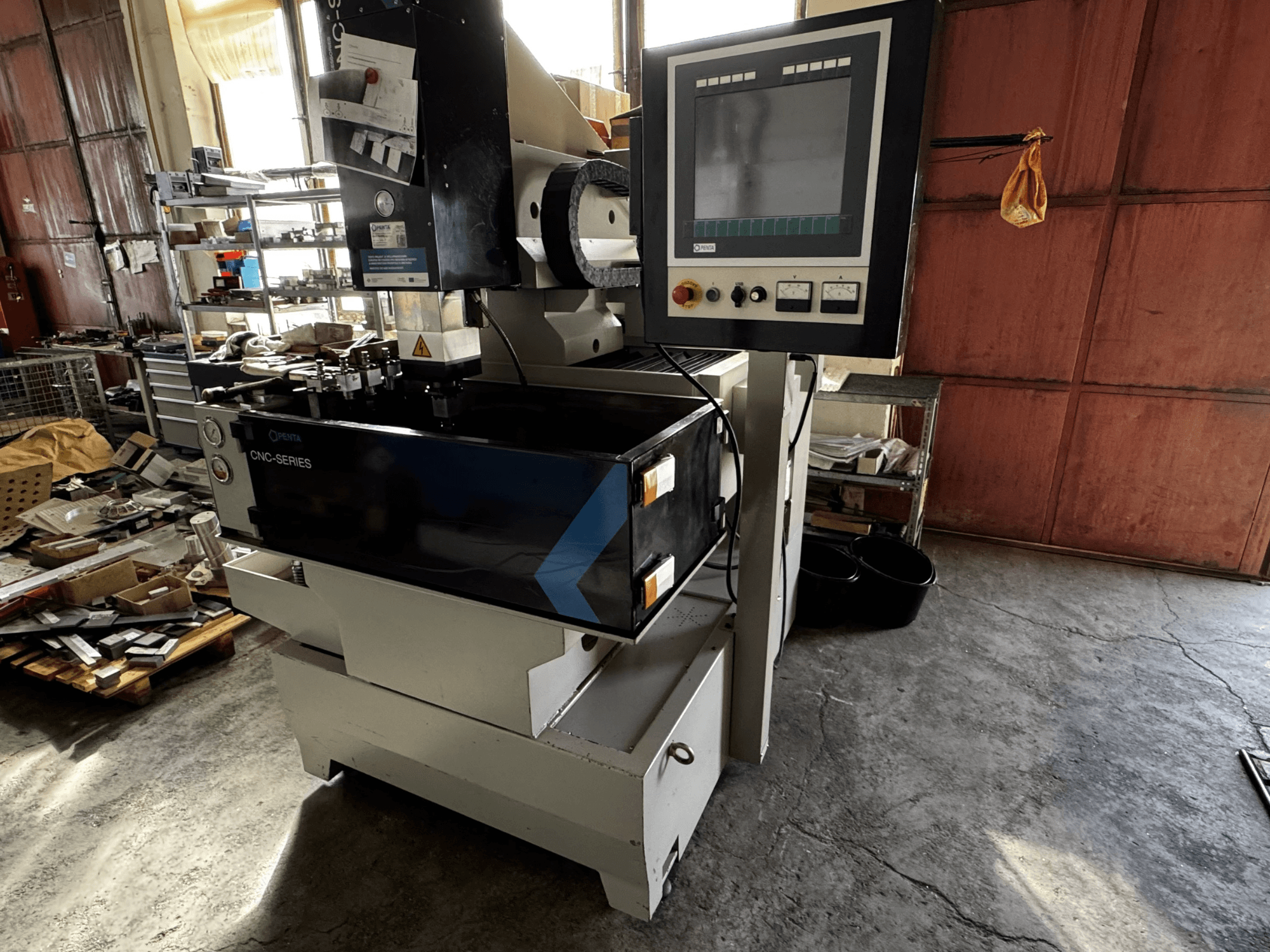 Máquina de electroerosión por penetración CNC PENTA 433GS, vista frontal. Muestra el panel de control, el portaelectrodos y la mesa de trabajo metálica.