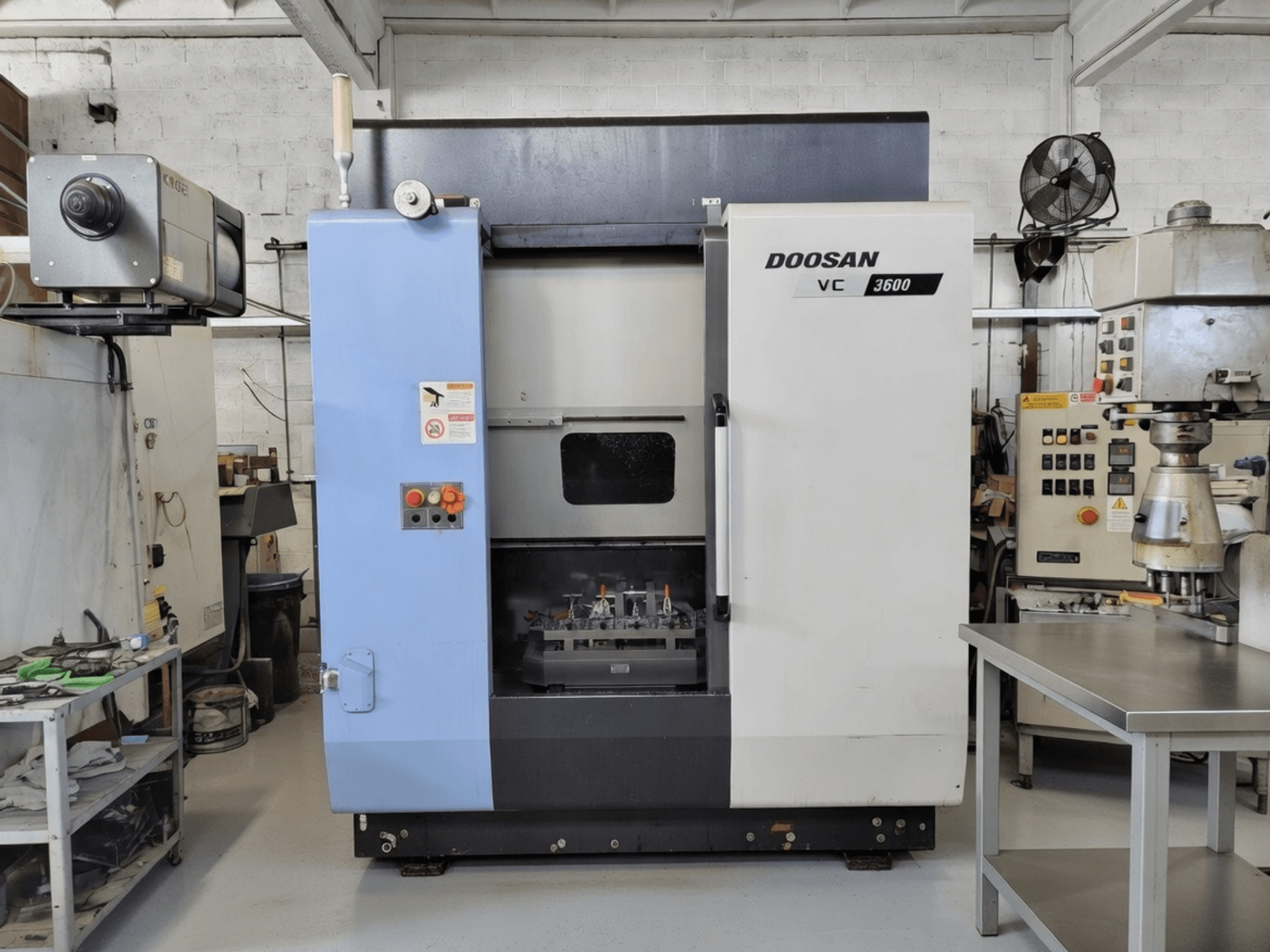 Centro de mecanizado vertical DOOSAN VC 3600 en vista frontal, con panel de control y puerta abierta que revela el espacio de trabajo.