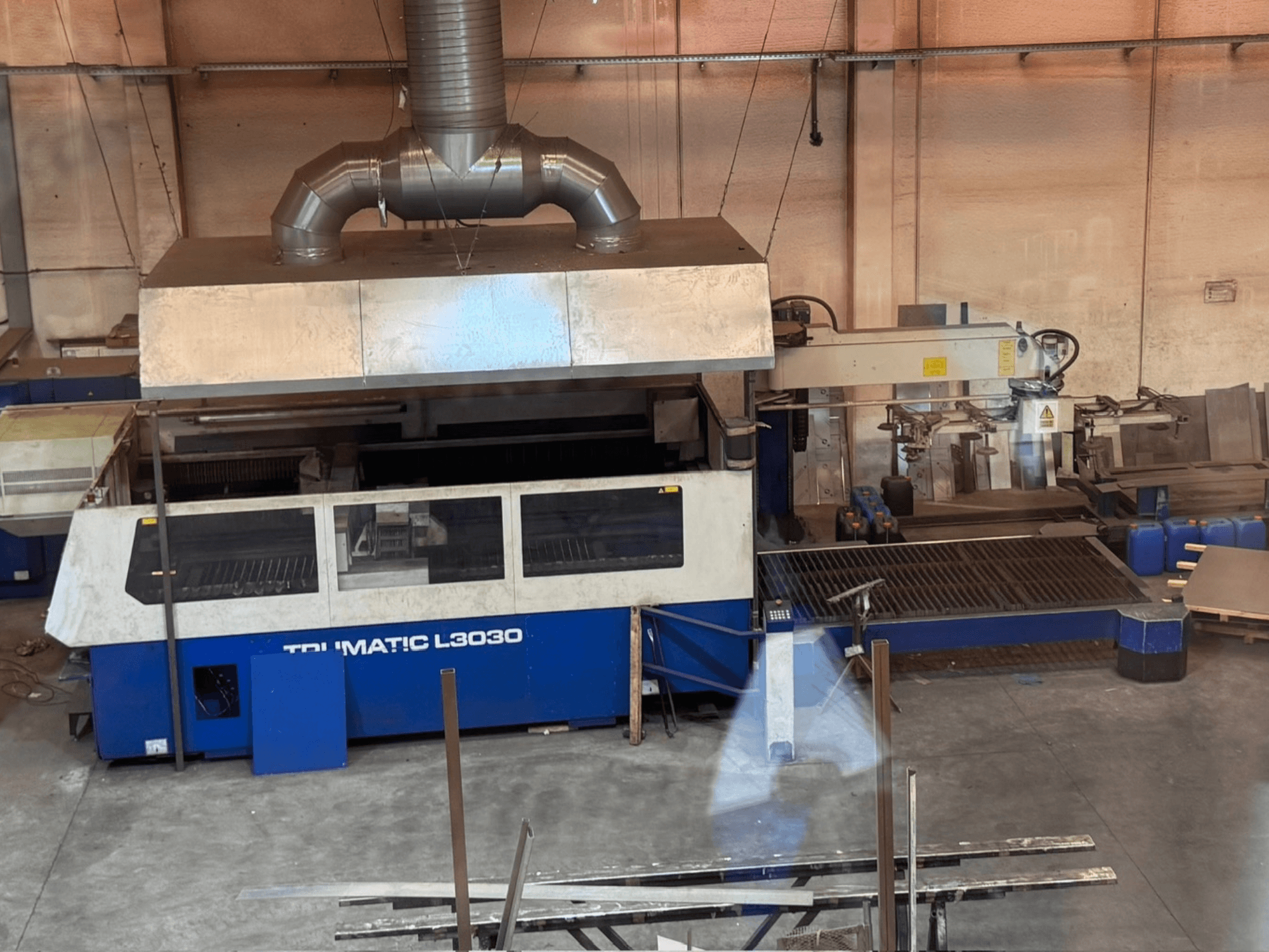 Máquina de corte por láser de CO₂ TRUMPF TRUMATIC L3030 en un taller; vista frontal en la que se aprecian el panel de control y la mesa de corte.