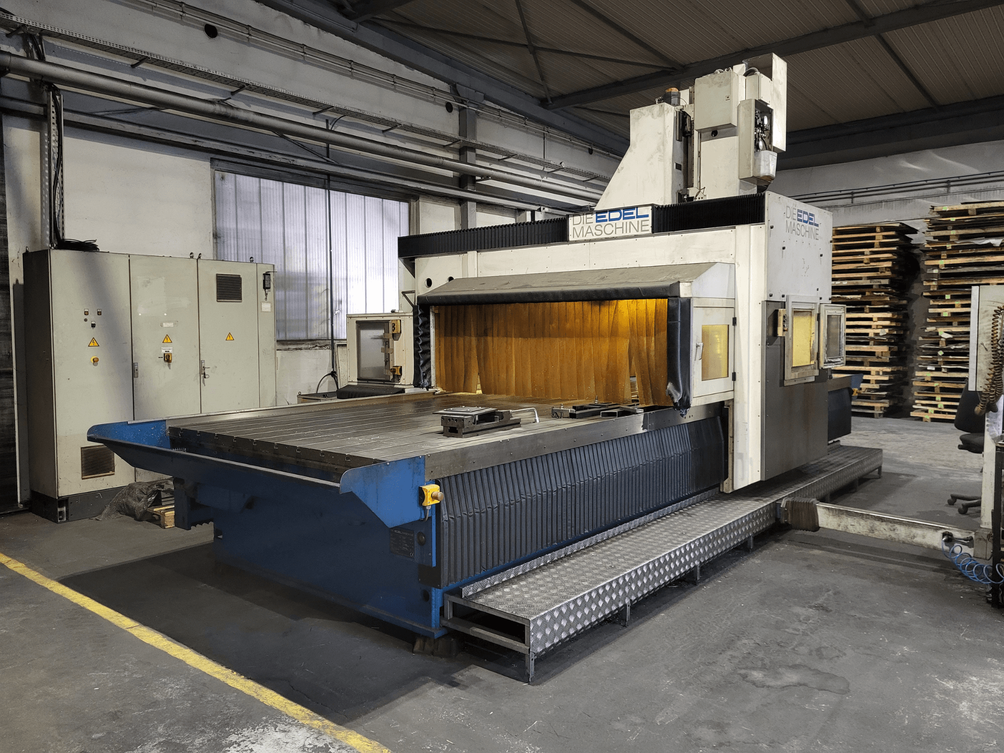 Fresadora de pórtico EDEL Koordimatic XL 4020, vista frontal, mostrando la gran mesa de trabajo y la unidad de control en un entorno industrial.