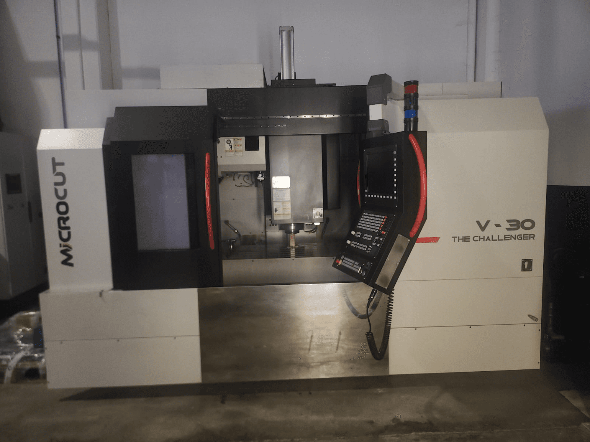 Microcut V-30 La máquina CNC Challenger, vista frontal, con panel de control, zona de corte y elementos de diseño industrial.