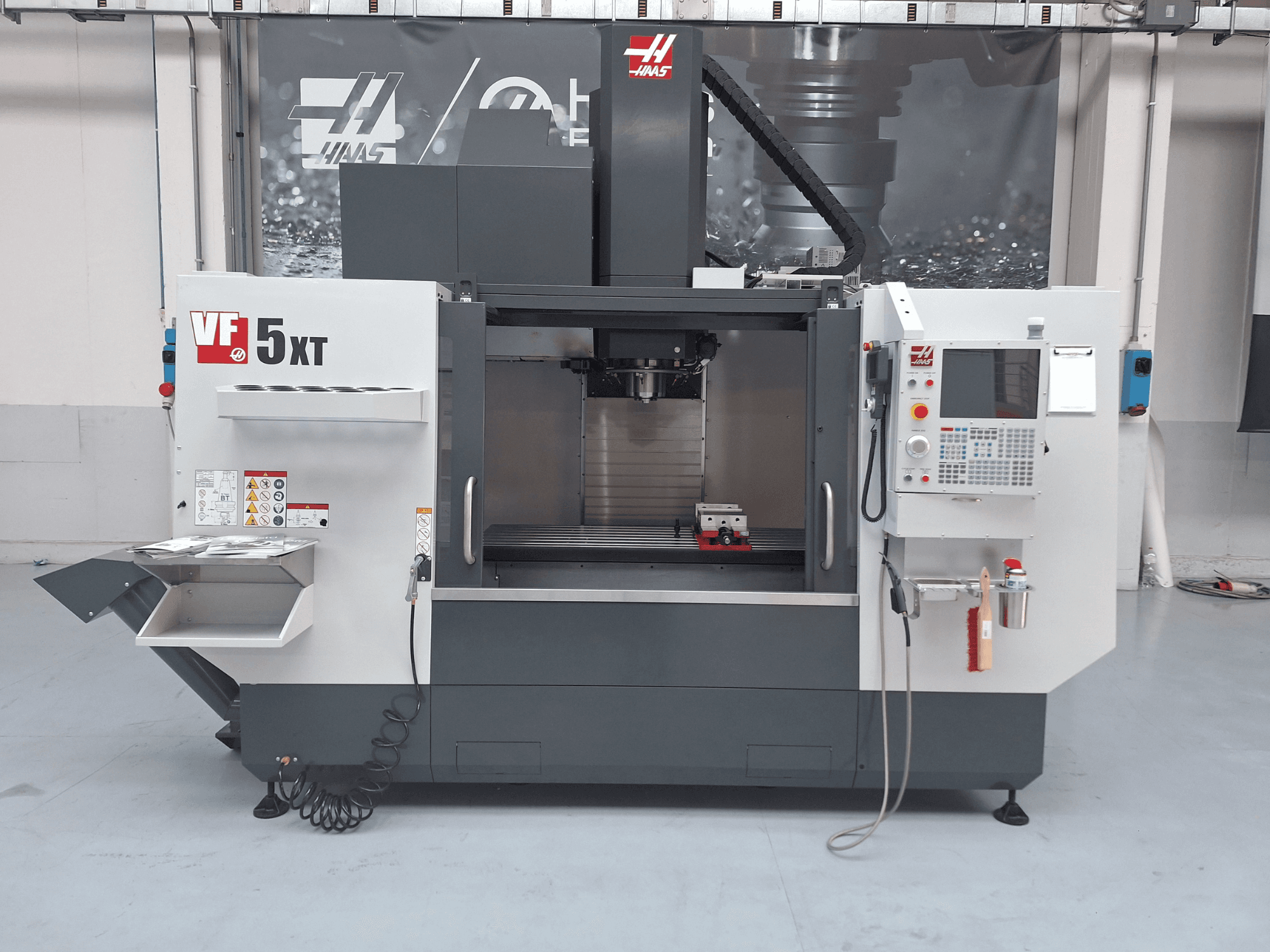 Centro de mecanizado vertical HAAS VF-5/50XT, vista frontal, en la que se aprecian el panel de control, la zona del husillo y el almacén de herramientas.