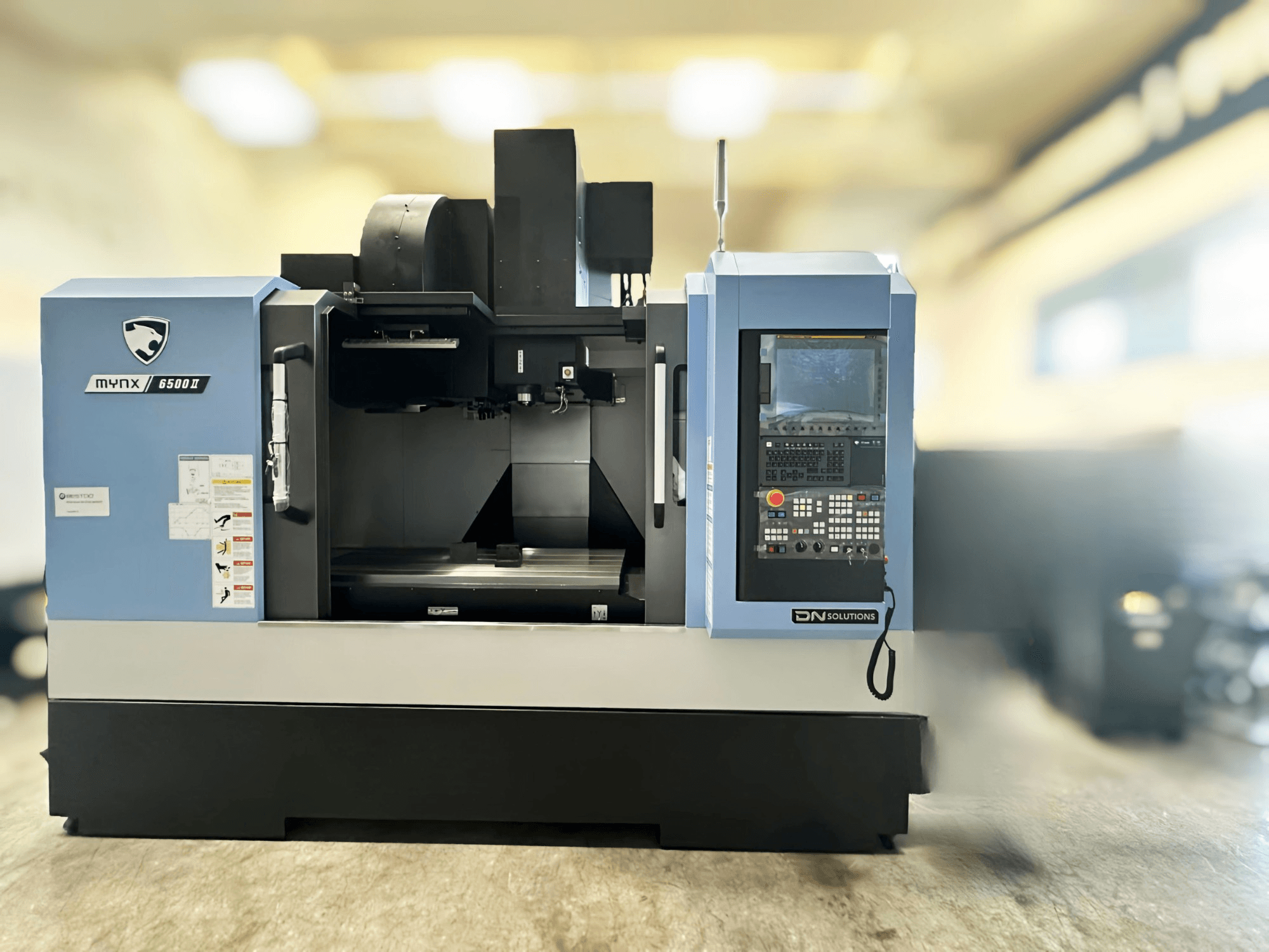 Centro de mecanizado vertical DN SOLUTIONS MYNX 6500 II, vista frontal en la que se aprecian el panel de control y la zona de trabajo.