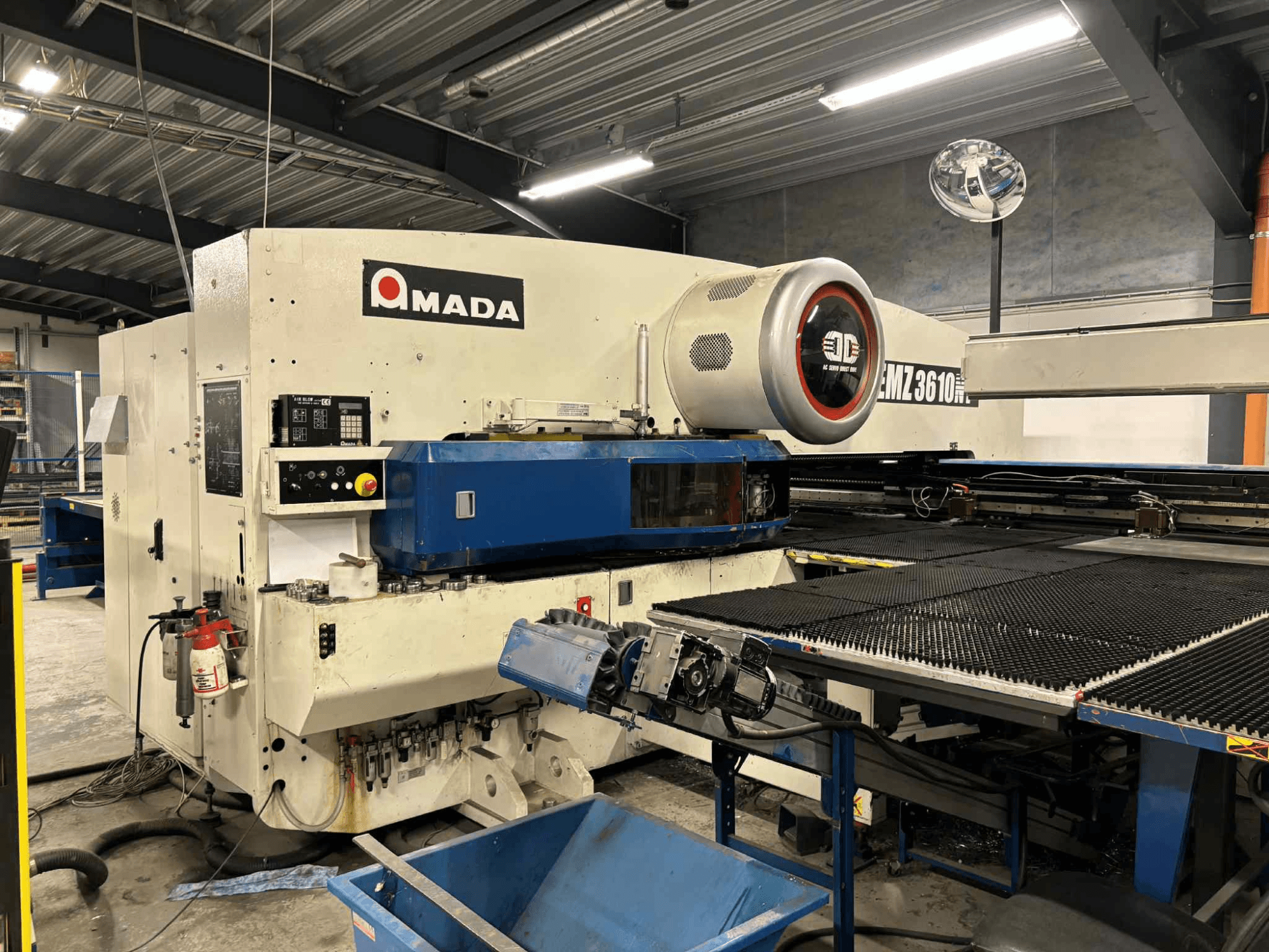 Punzonadora Amada EMZ3610H vista de frente; incluye controles de funcionamiento, bancada azul y equipo de seguridad.