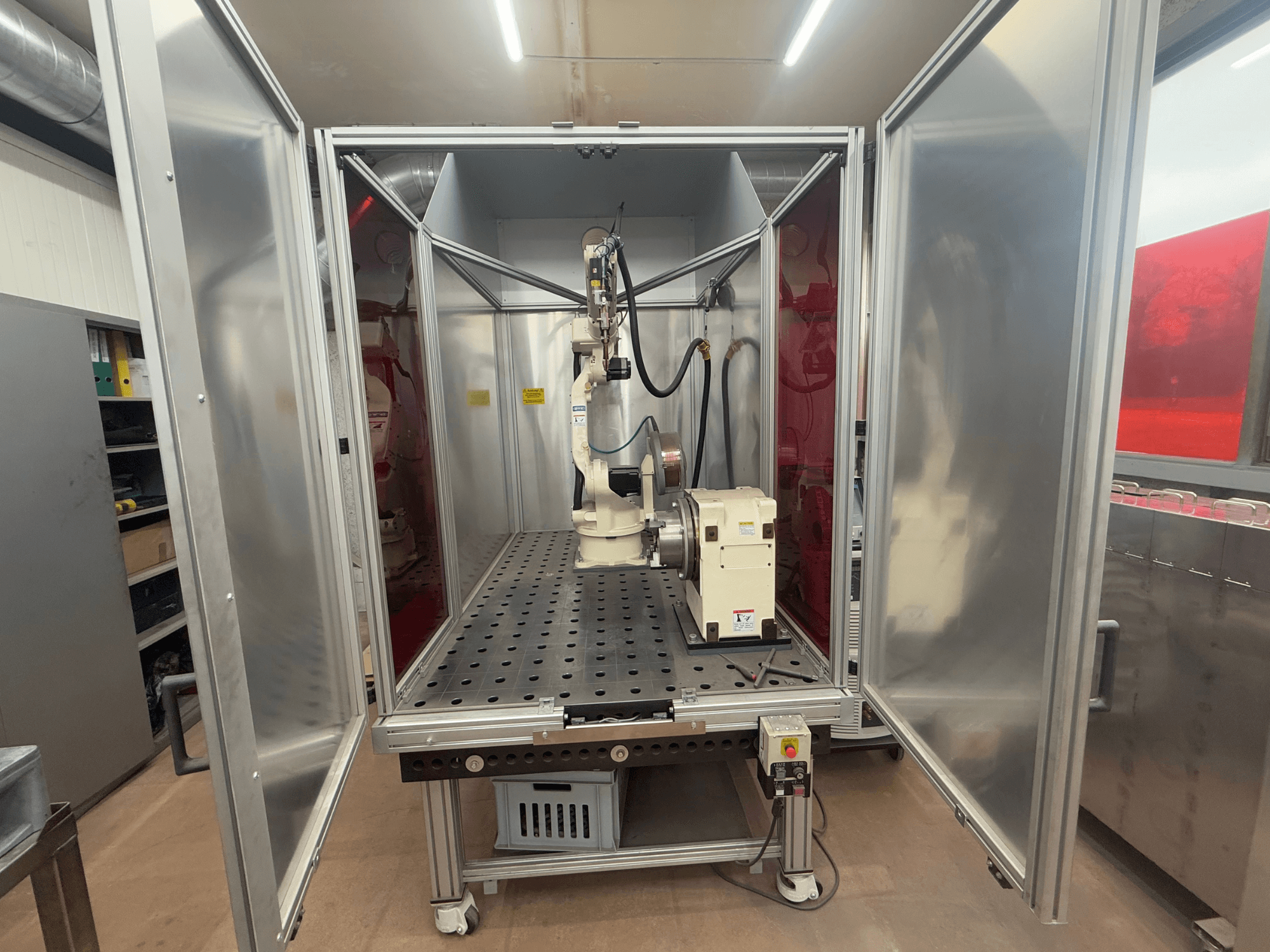 Robot de soldadura OTC Daihen EASY ARC V02.04 en una carcasa metálica, visto de frente, mostrando su brazo articulado y el panel de control.