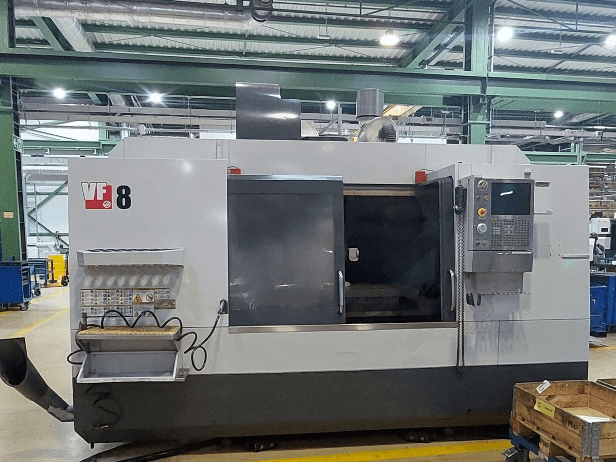 Centro de mecanizado vertical HAAS VF-8, vista frontal; cuenta con un panel de control y una zona de carga, y está diseñado para tareas de mecanizado de precisión.