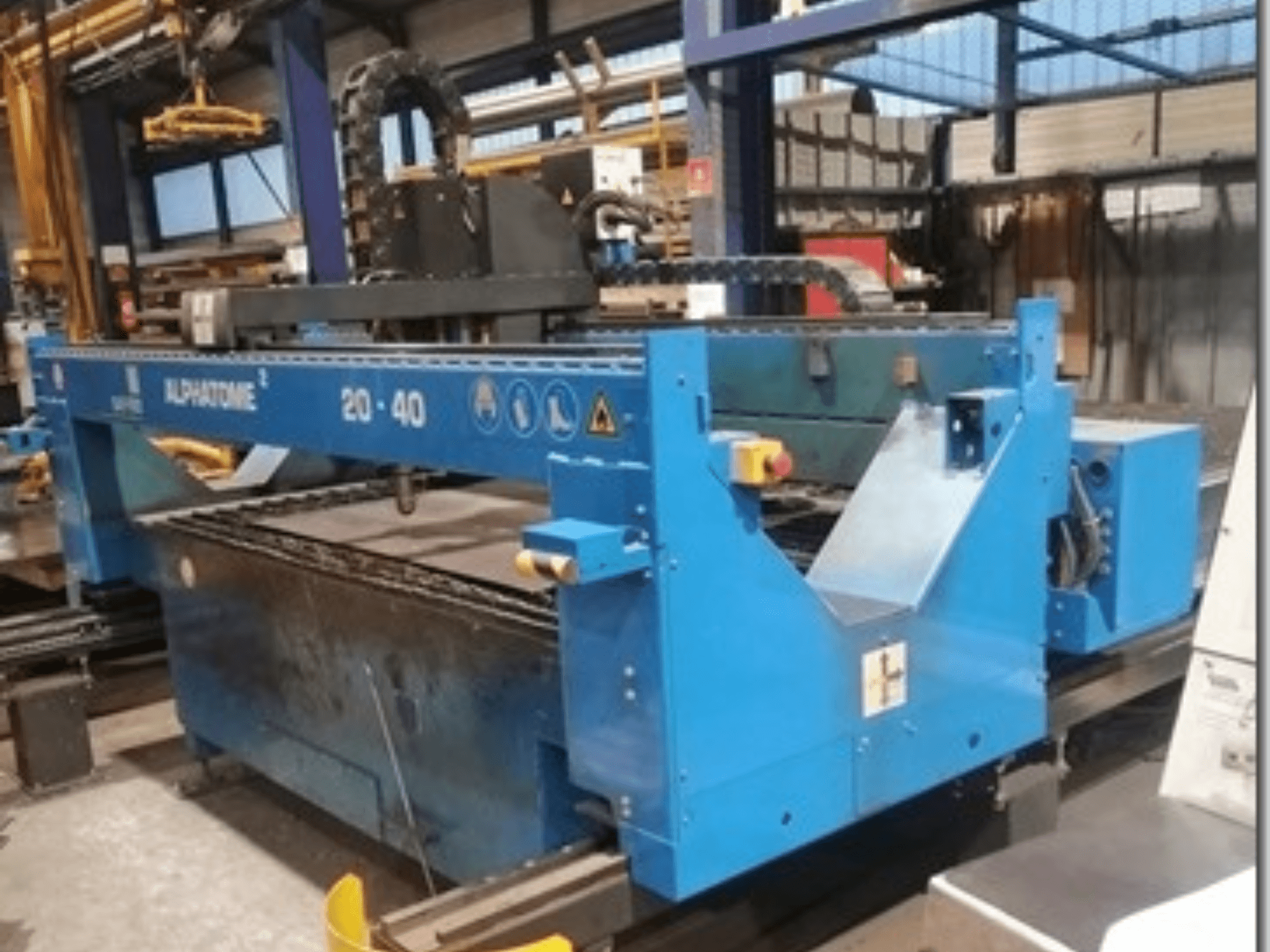 Máquina CNC ALPHATOME 20-40 azul, vista frontal, con la zona de corte y el panel de control visibles, diseñada para la fabricación de precisión.