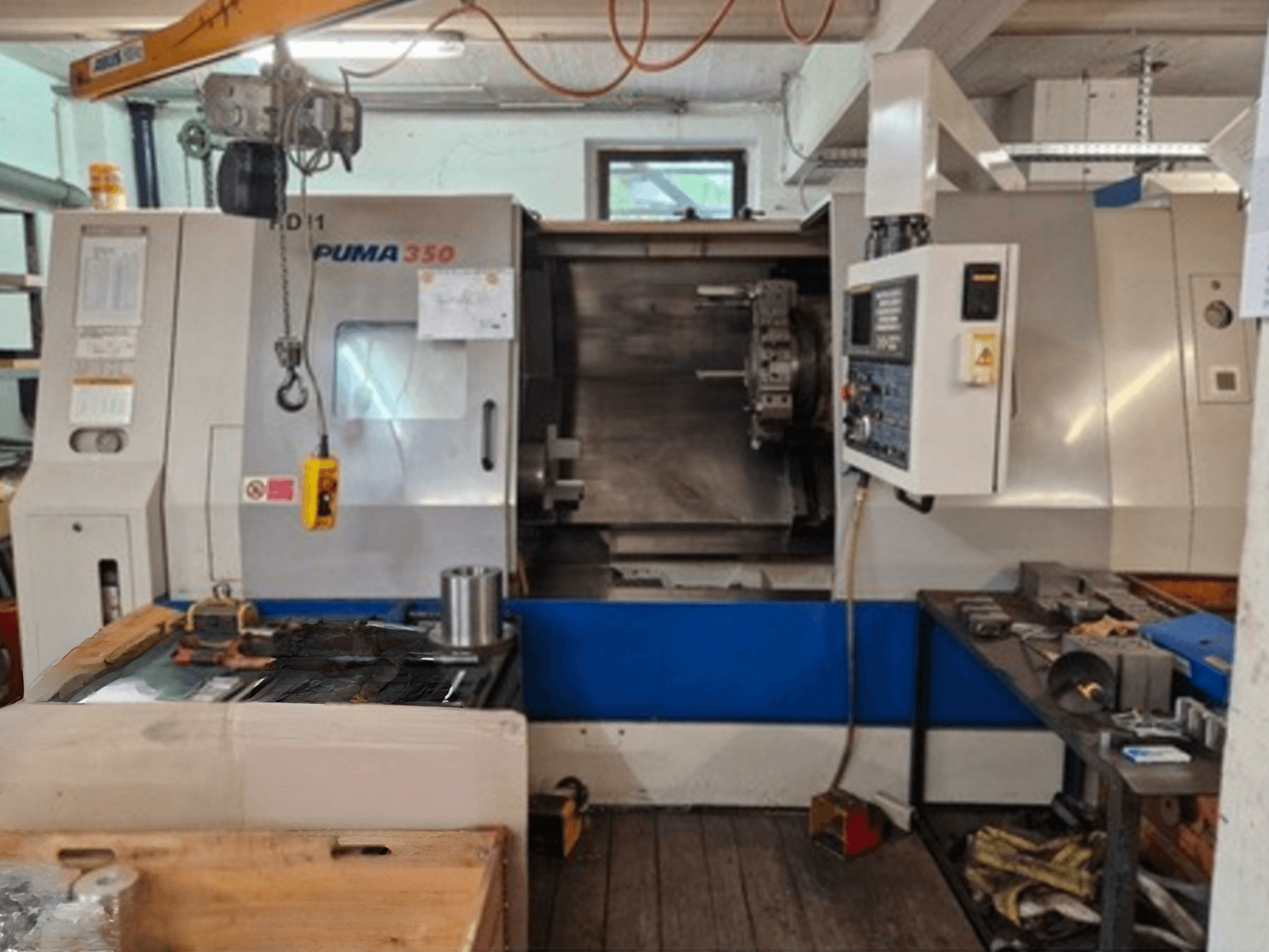 Tornos horizontales DAEWOO Puma 350, vista lateral, mostrando el panel de control y la zona de trabajo con herramientas y materiales cerca.