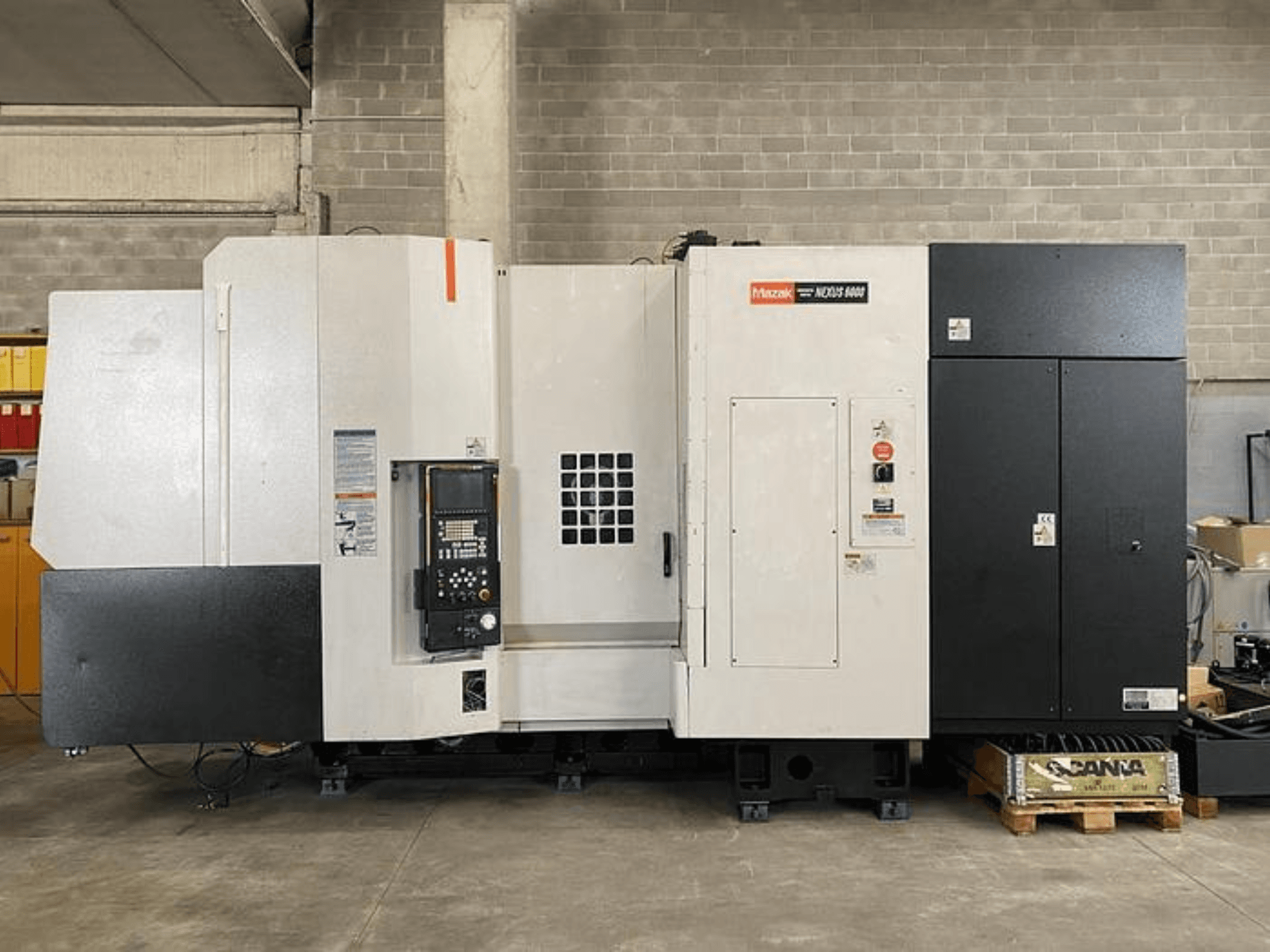 Torno CNC Mazak NEXUS 6400, vista frontal, con panel de control, interruptor de encendido y carcasa bicolor en blanco y negro.