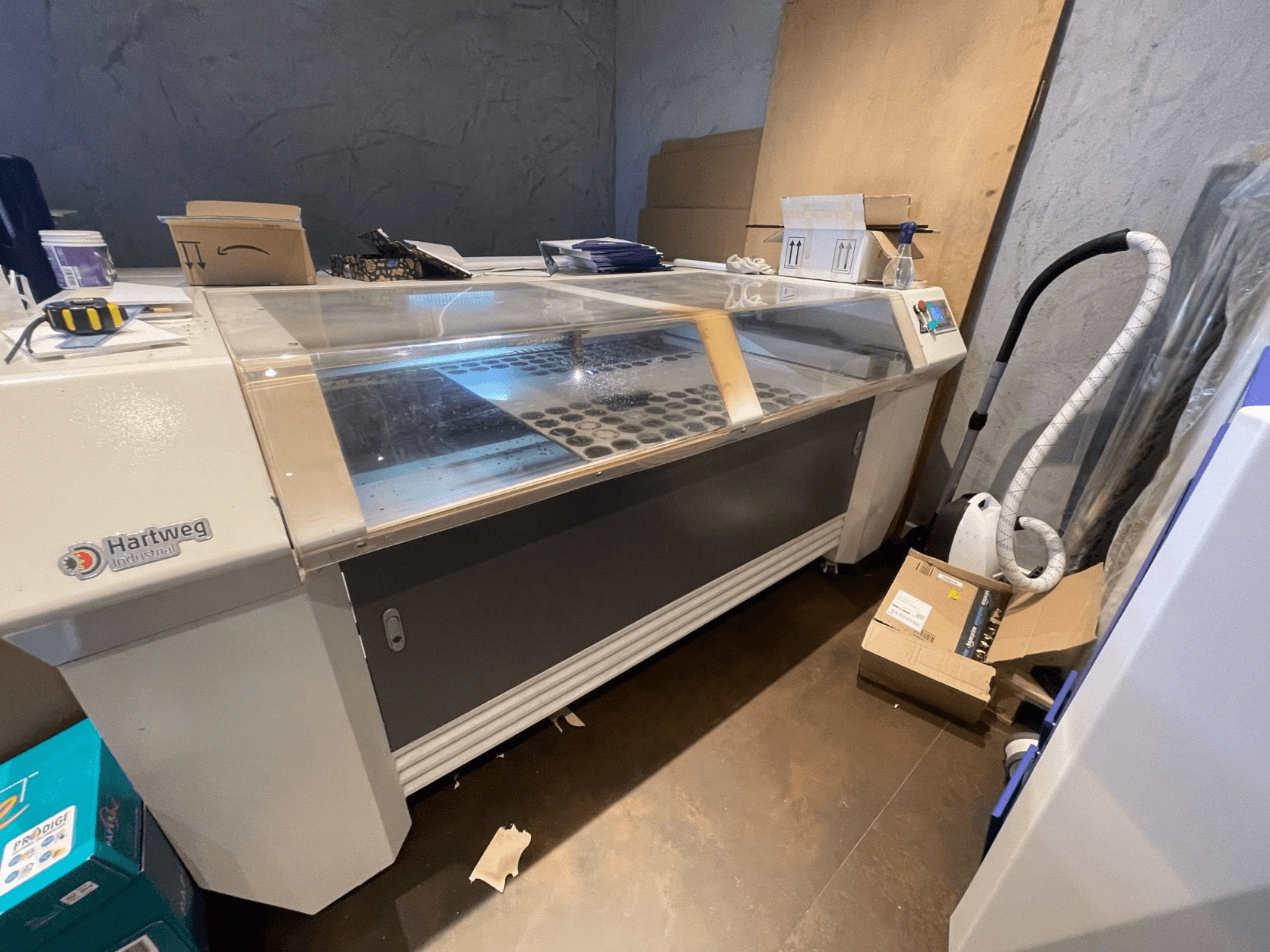 Máquina de corte por láser de CO2 Bodor CL-1610XUF en vista lateral, mostrando el área de trabajo con las ranuras de material y el panel de control.