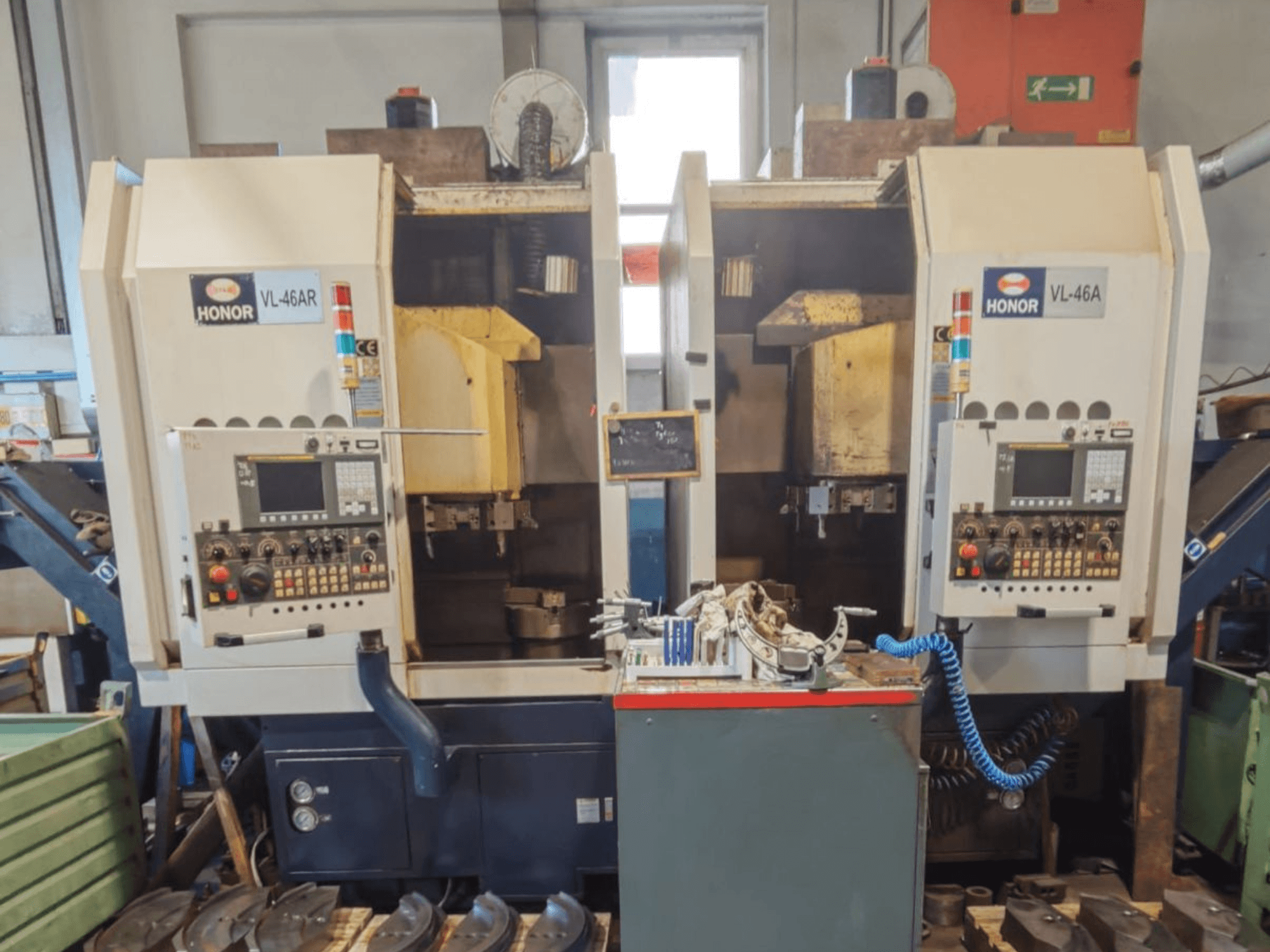 Torno vertical HONOR SEIKI VL 46 AR con dos estaciones de trabajo; vista frontal en la que se aprecian los paneles de control y las herramientas.