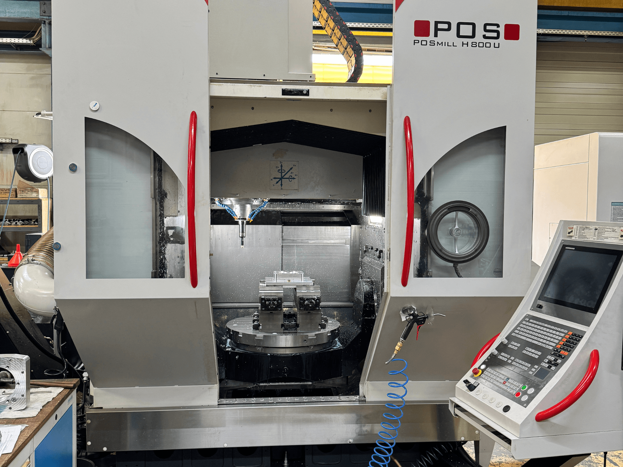 Centro de mecanizado vertical POSmill H 800 U, vista frontal en la que se aprecian los componentes internos, el sistema de refrigeración y el panel de control.