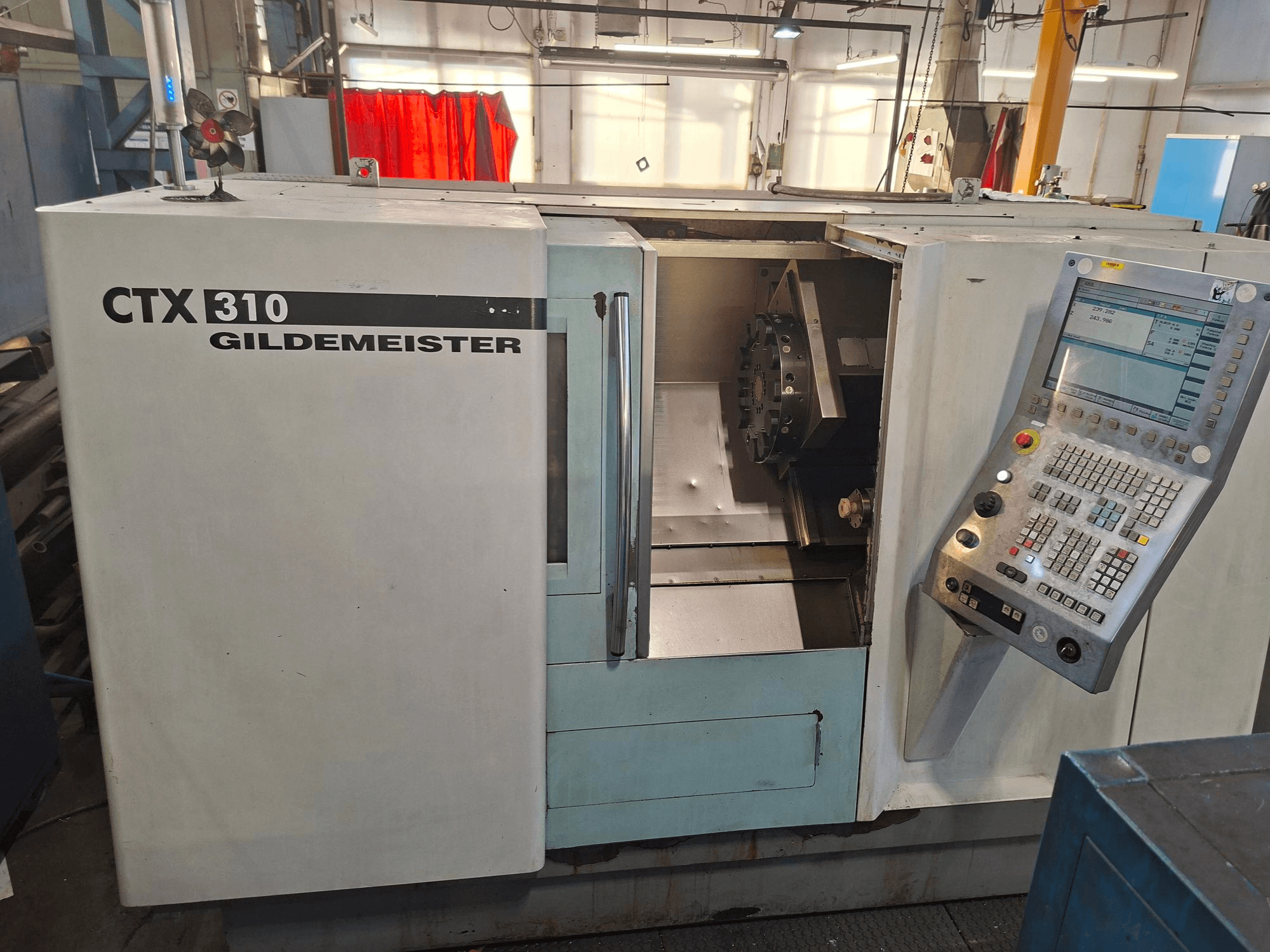 Máquina de torneado horizontal DMG CTX 310, vista frontal, con panel de control y acceso abierto a la zona de trabajo.