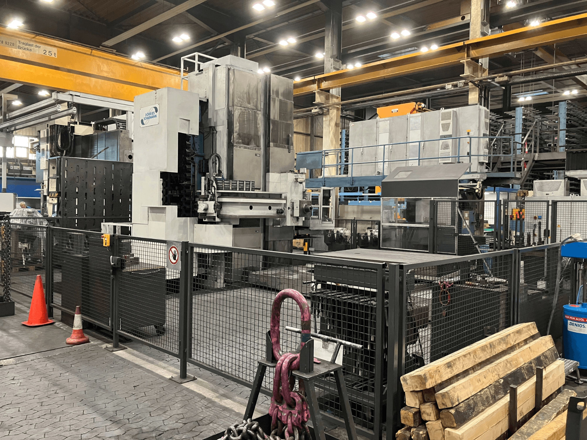 Máquina de mandrinado DÖRRIES SCHARMANN Heavycut 1.2 TDV4 en su entorno de fábrica, vista lateral con barreras de seguridad y herramientas en las inmediaciones.