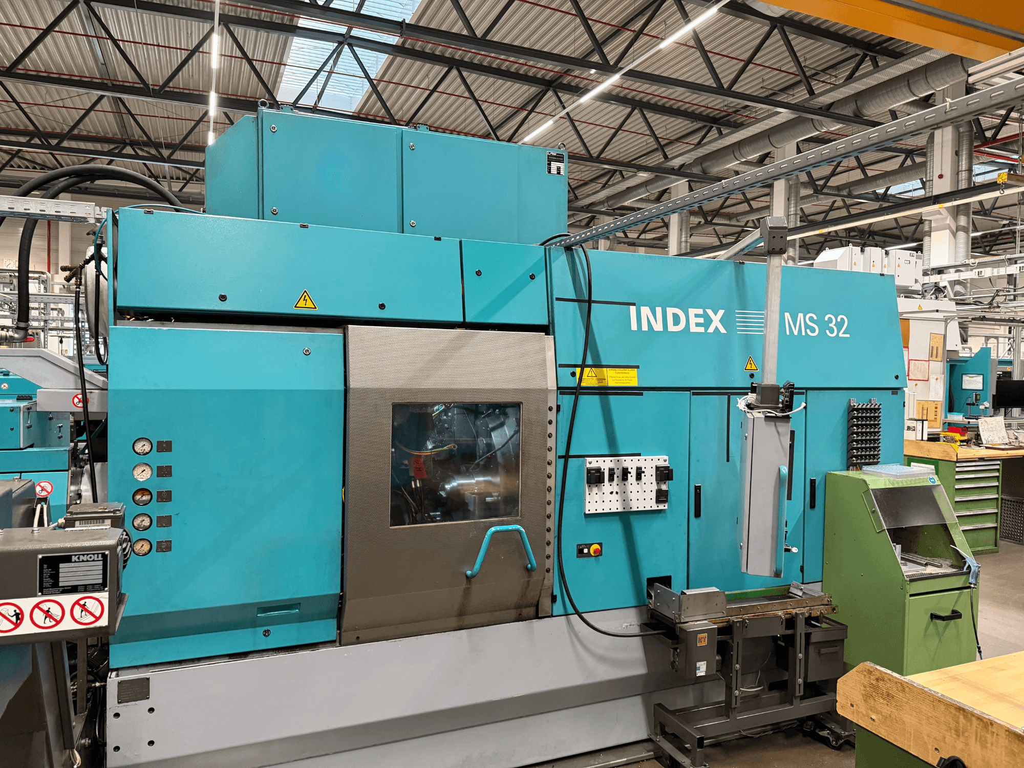 Torno multihusillo Index MS32-P, vista frontal con el panel de control y el sistema de refrigeración. Ideal para el mecanizado de precisión.