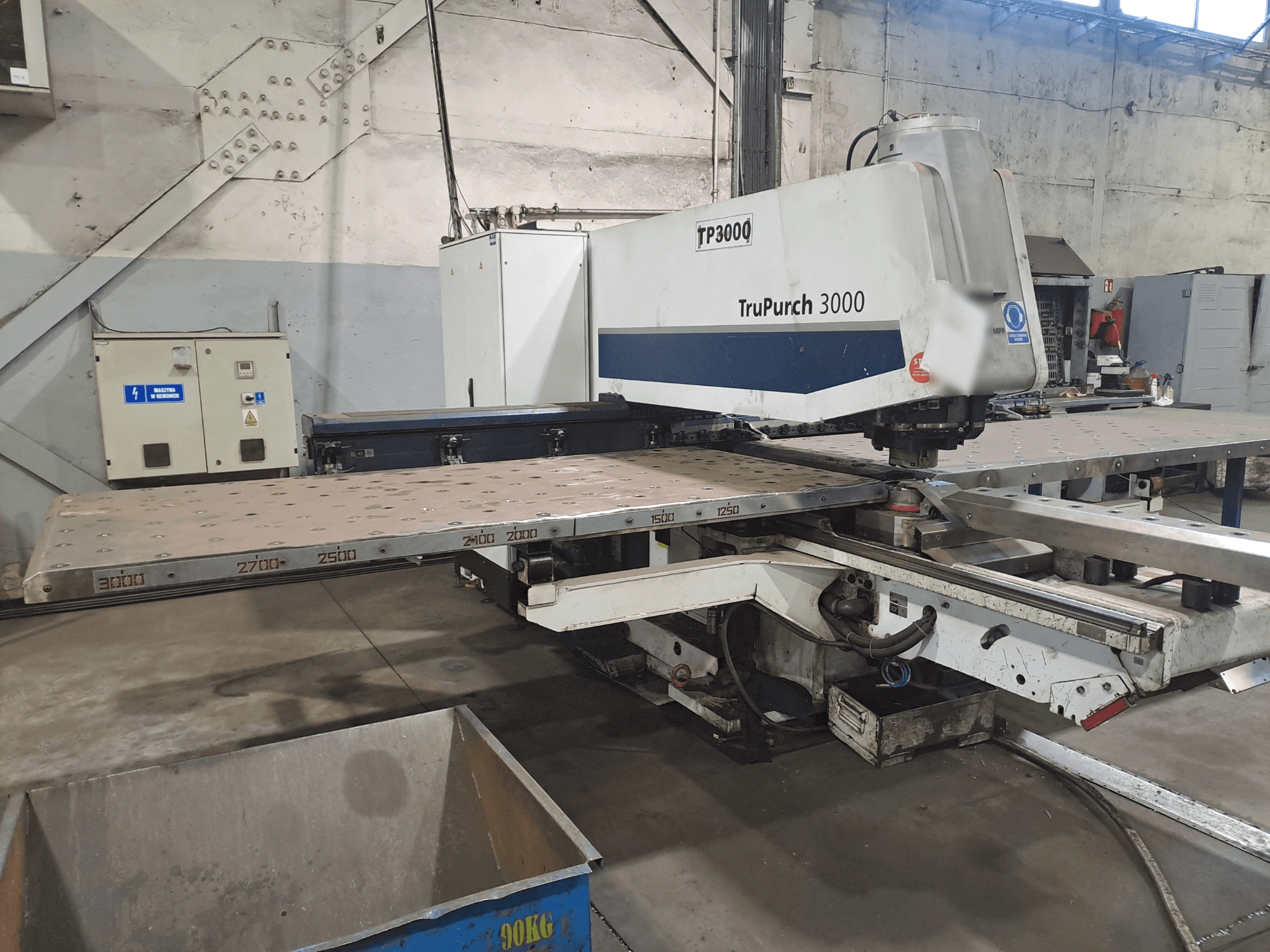 Máquina CNC TruPunch 3000 mostrada de frente, con una gran placa metálica y marcas de medición, en un entorno industrial.