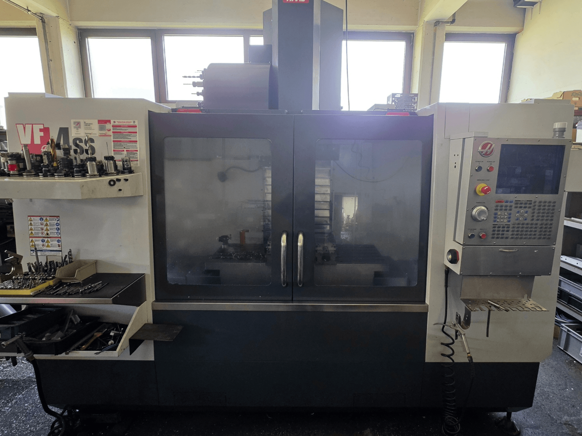 Vista frontal del centro de mecanizado vertical HAAS VF 34SS, mostrando el panel de control y la zona de almacenamiento de herramientas.