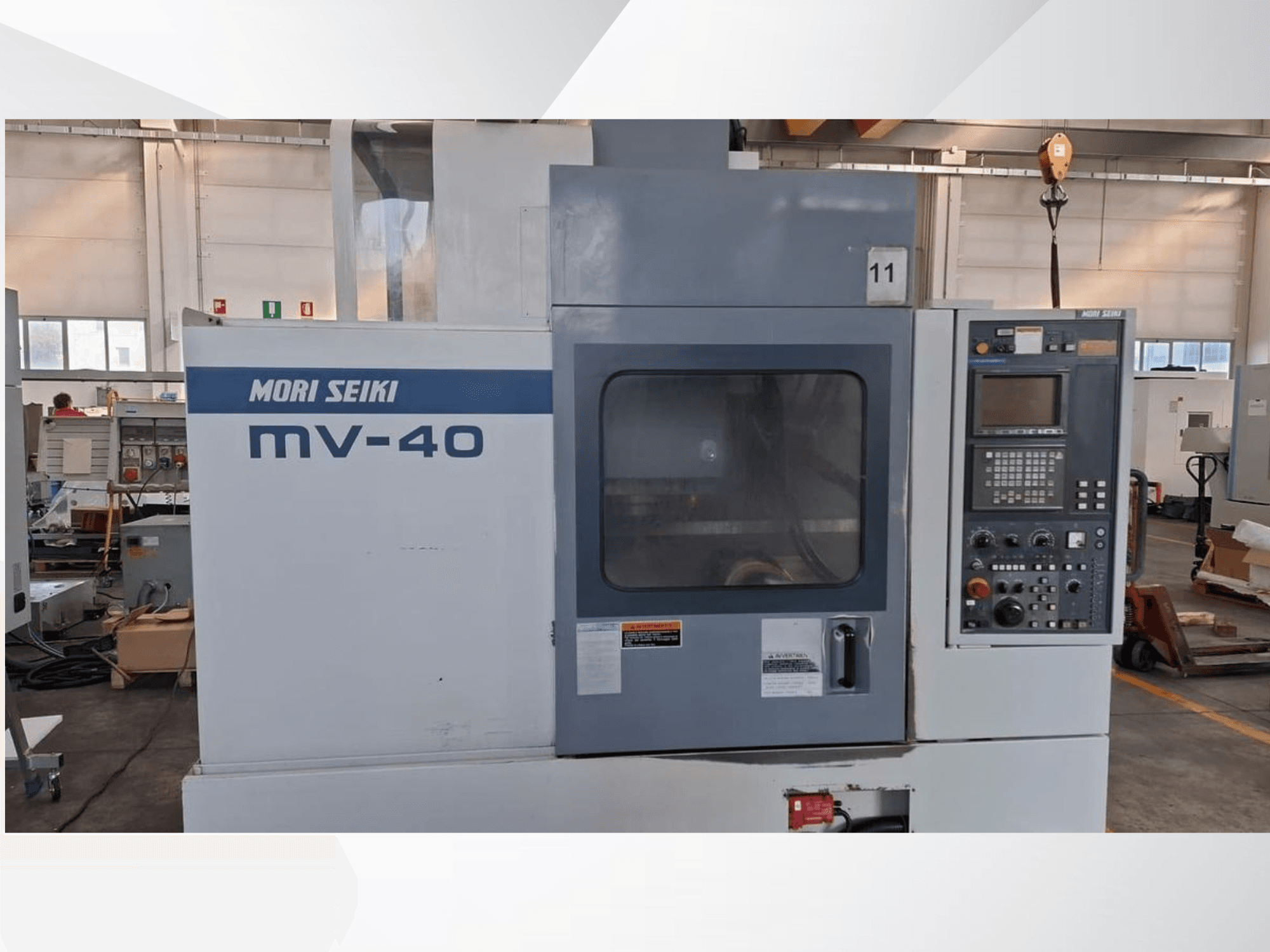 Centro de mecanizado vertical MORI SEIKI MV-40, vista frontal mostrando el panel de control y la ventana, en un entorno de taller.