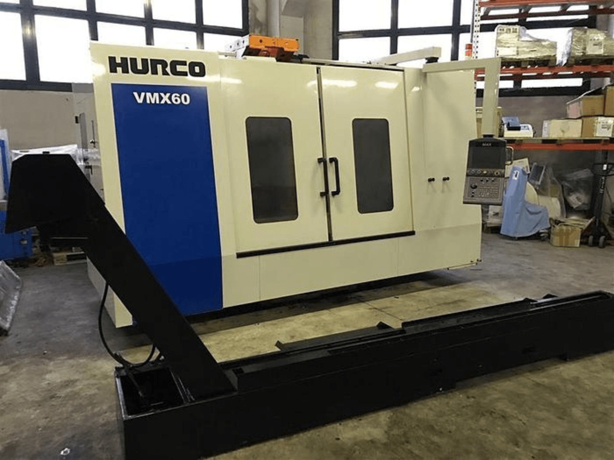 Máquina CNC HURCO VMX60 en un taller, vista frontal, con panel de control y carril de soporte negro acoplado.