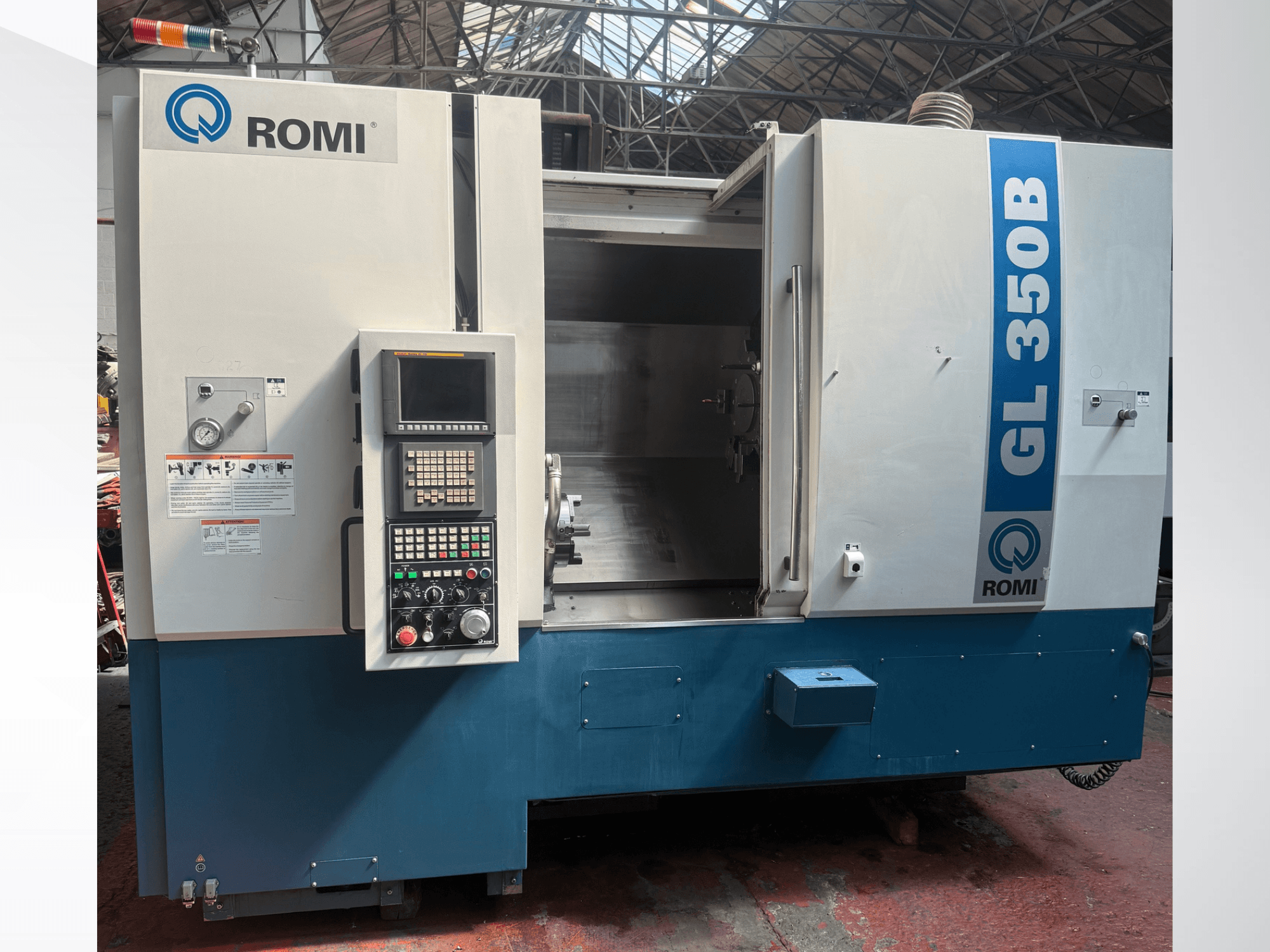 Vista frontal del torno horizontal Romi GL 350B, mostrando el panel de control y el área de trabajo abierta.