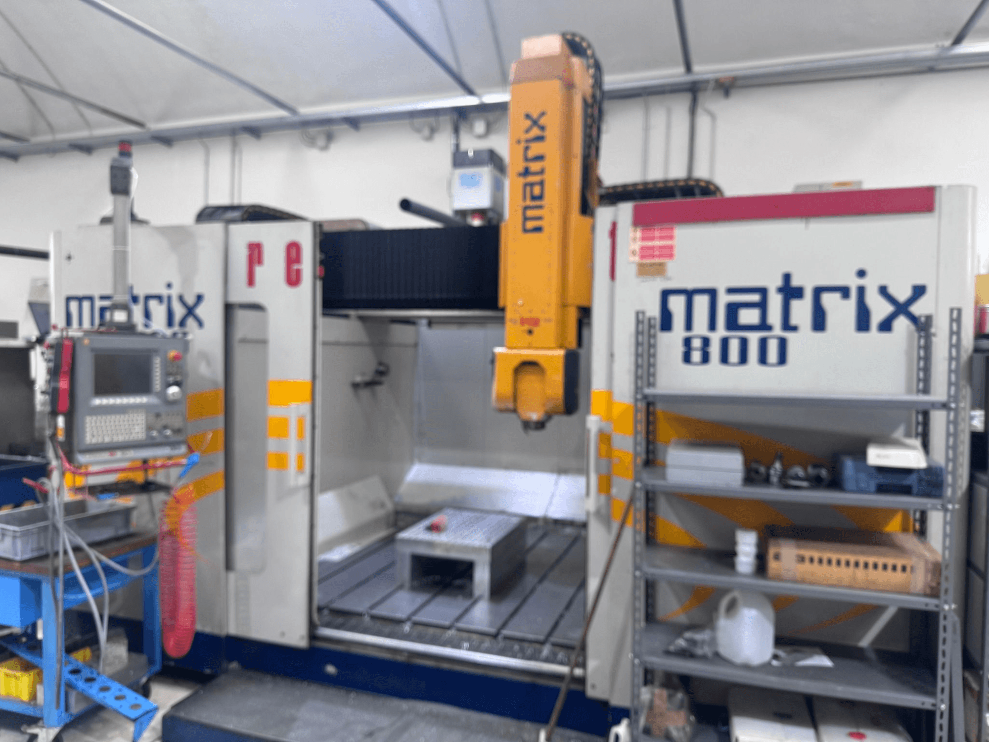 Máquina CNC Matrix 800 en una vista de taller, con panel de control, herramientas y mesa de trabajo con varios objetos.