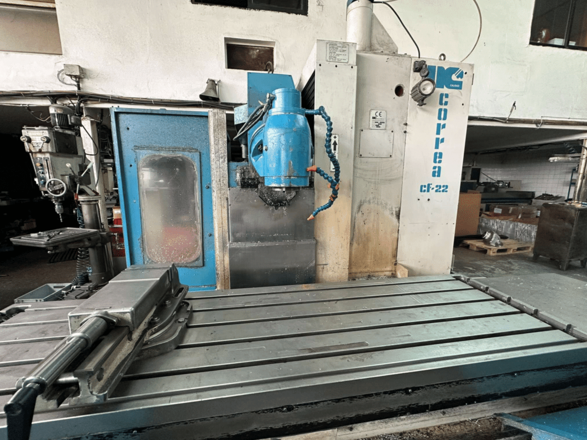 Fresadora Correa CF-22 mostrada desde una vista frontal, de diseño azul y plata, con mesa deslizante y cabezal de corte.