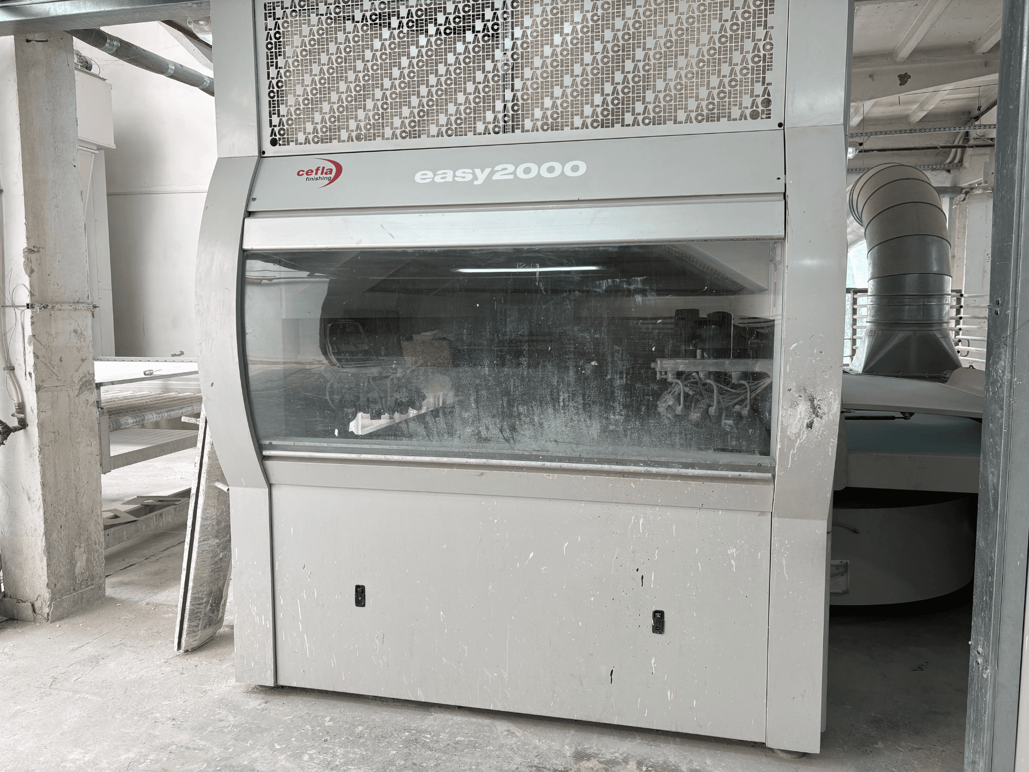 Máquina Cefla EASY 2000 D vista de frente, con un gran panel transparente, superficie con restos de polvo y componentes internos visibles.