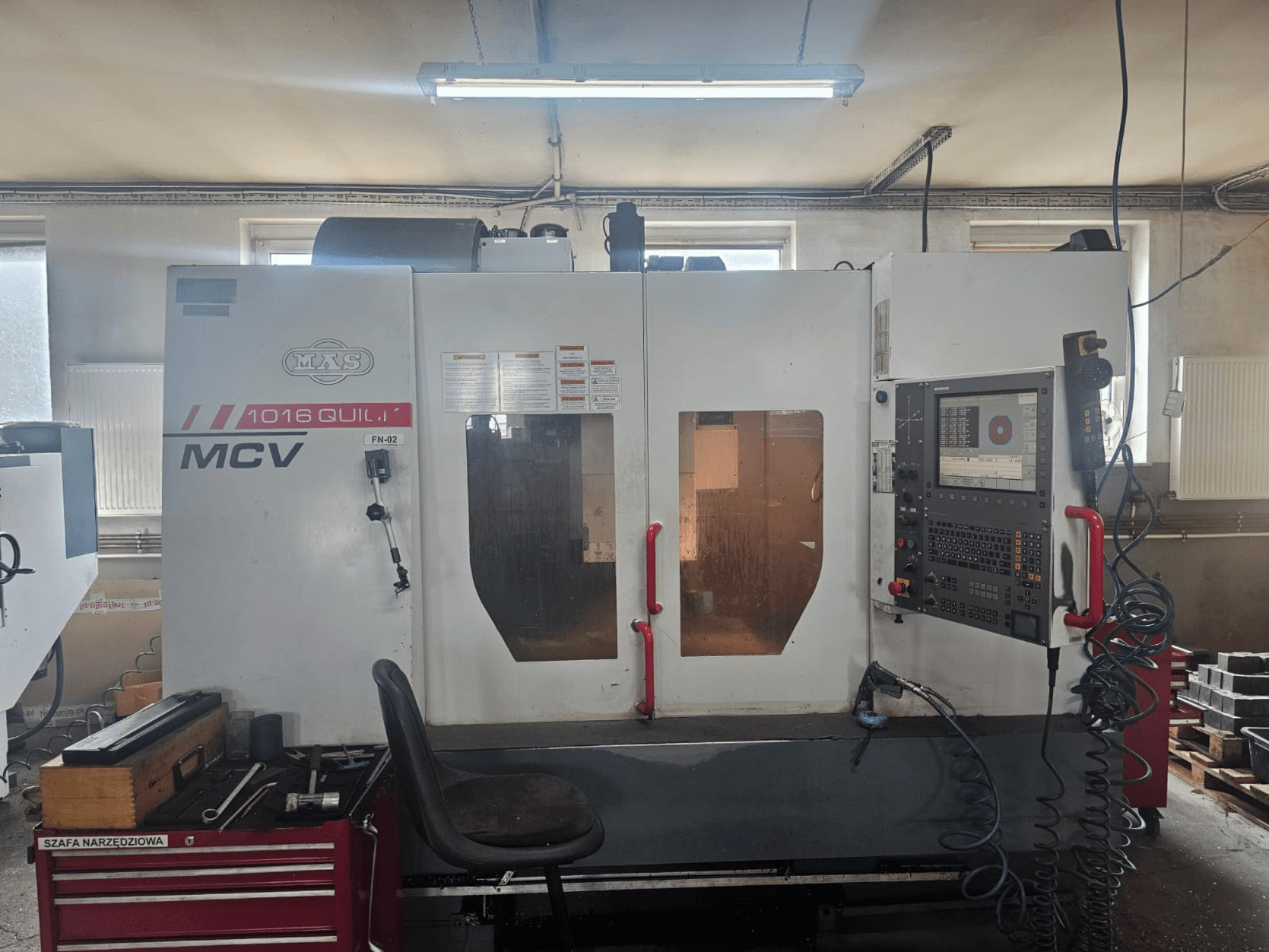 Máquina CNC MVS MCV 1016 QUILL, vista frontal, con panel de control, cajón de herramientas y espacio de trabajo con herramientas.