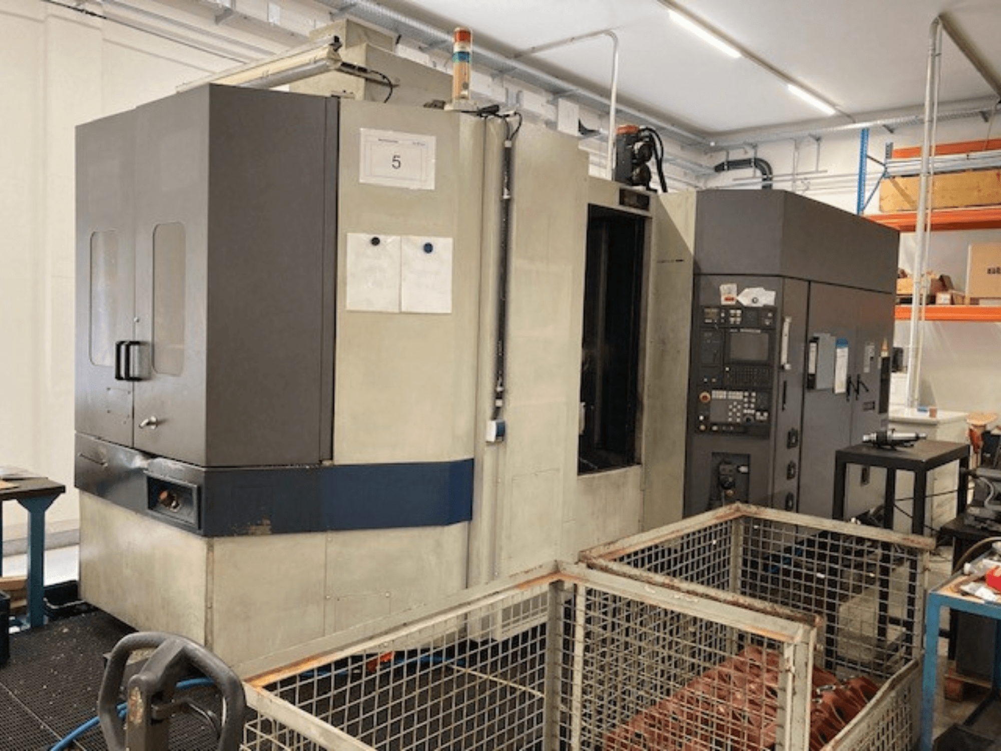 Centro de mecanizado horizontal MORI SEIKI SH633, vista frontal, mostrando el panel de control y las características de seguridad.
